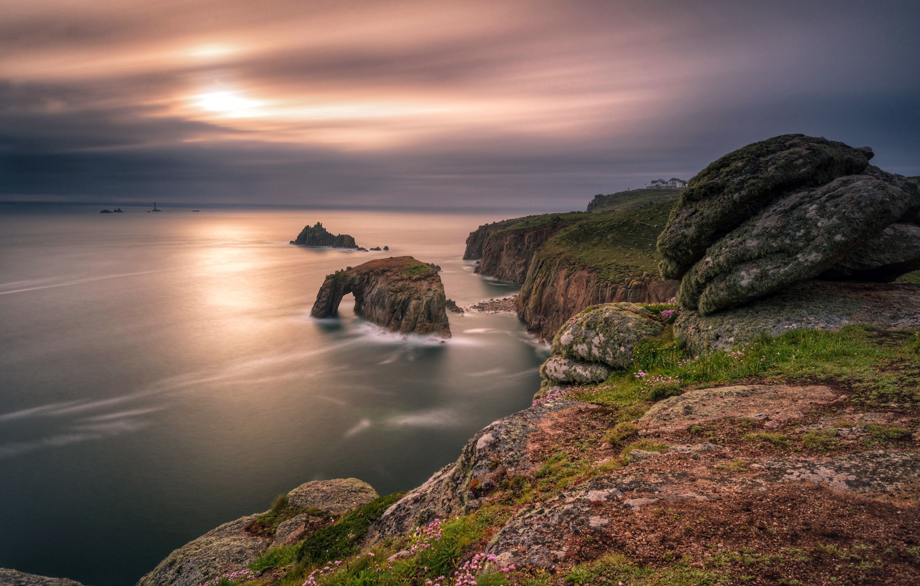 Coastline with rock arch and lighthouse at sunset HD Wallpaper