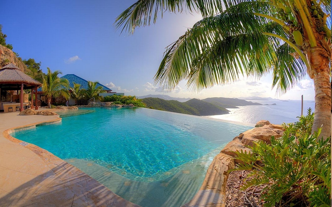 Infinity pool overlooking tropical islands at sunset HD Wallpaper