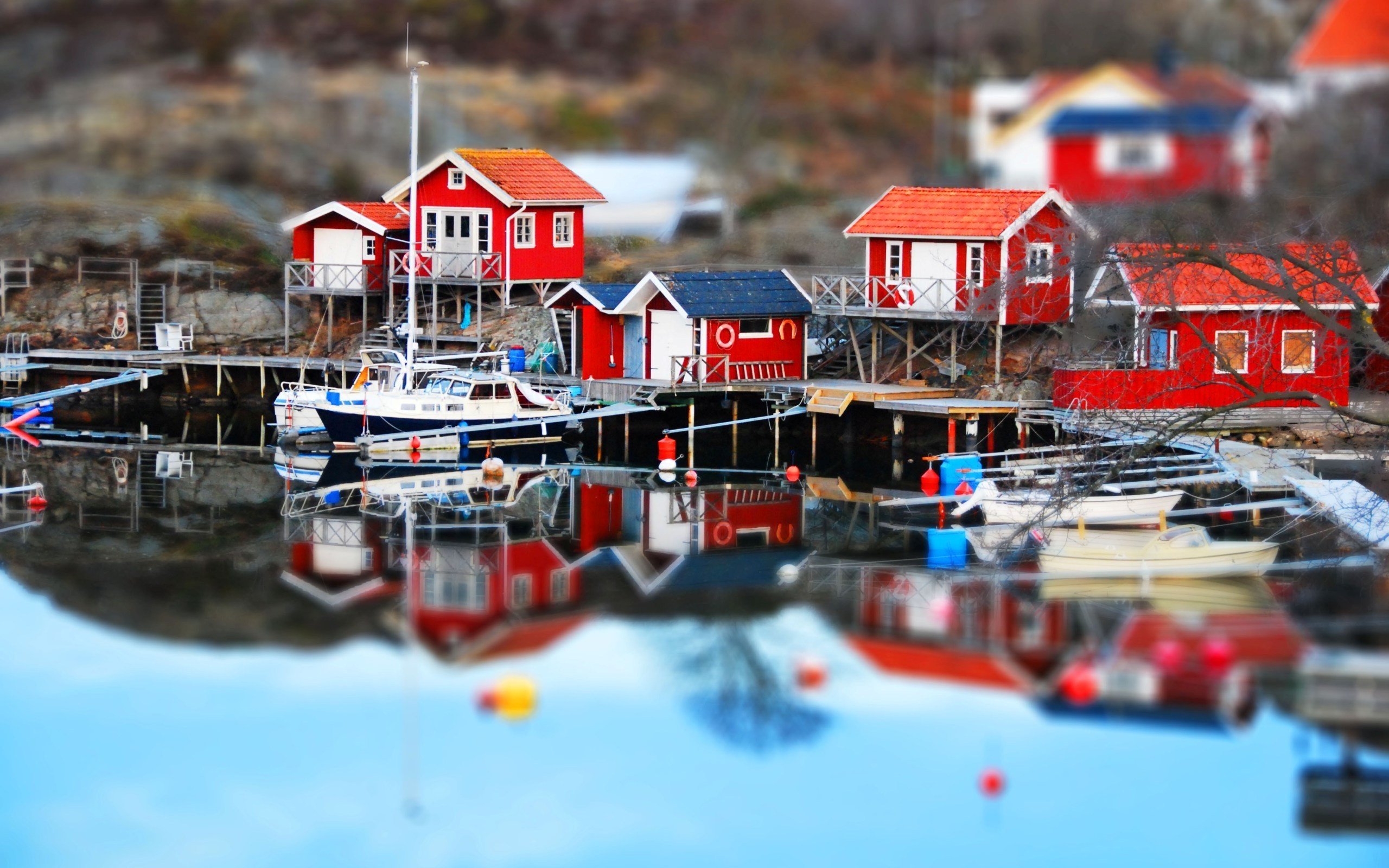 Tilt shift dock with red houses and boats in Sweden HD Wallpaper