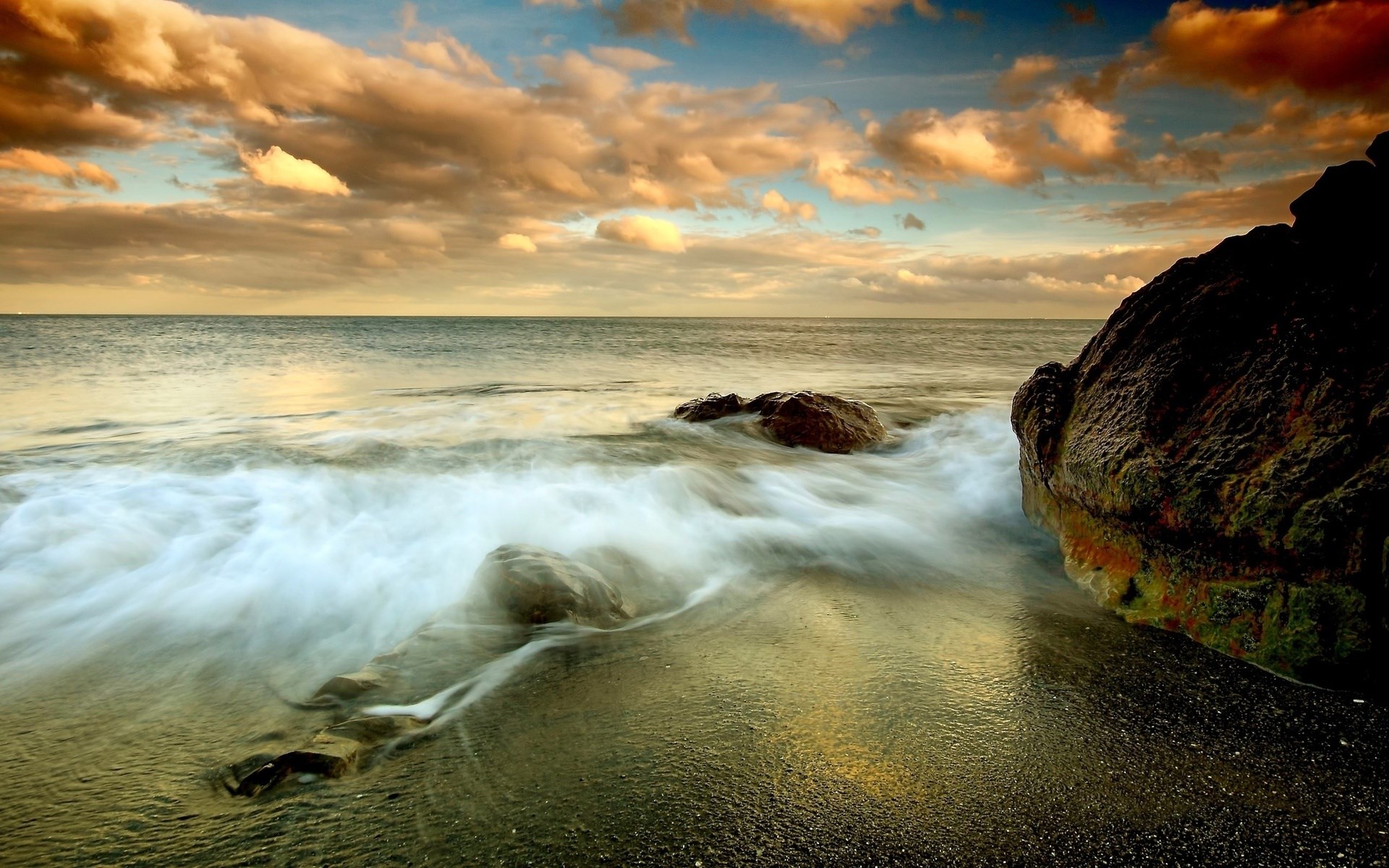 Waves crashing on a rocky shore at sunset HD Wallpaper