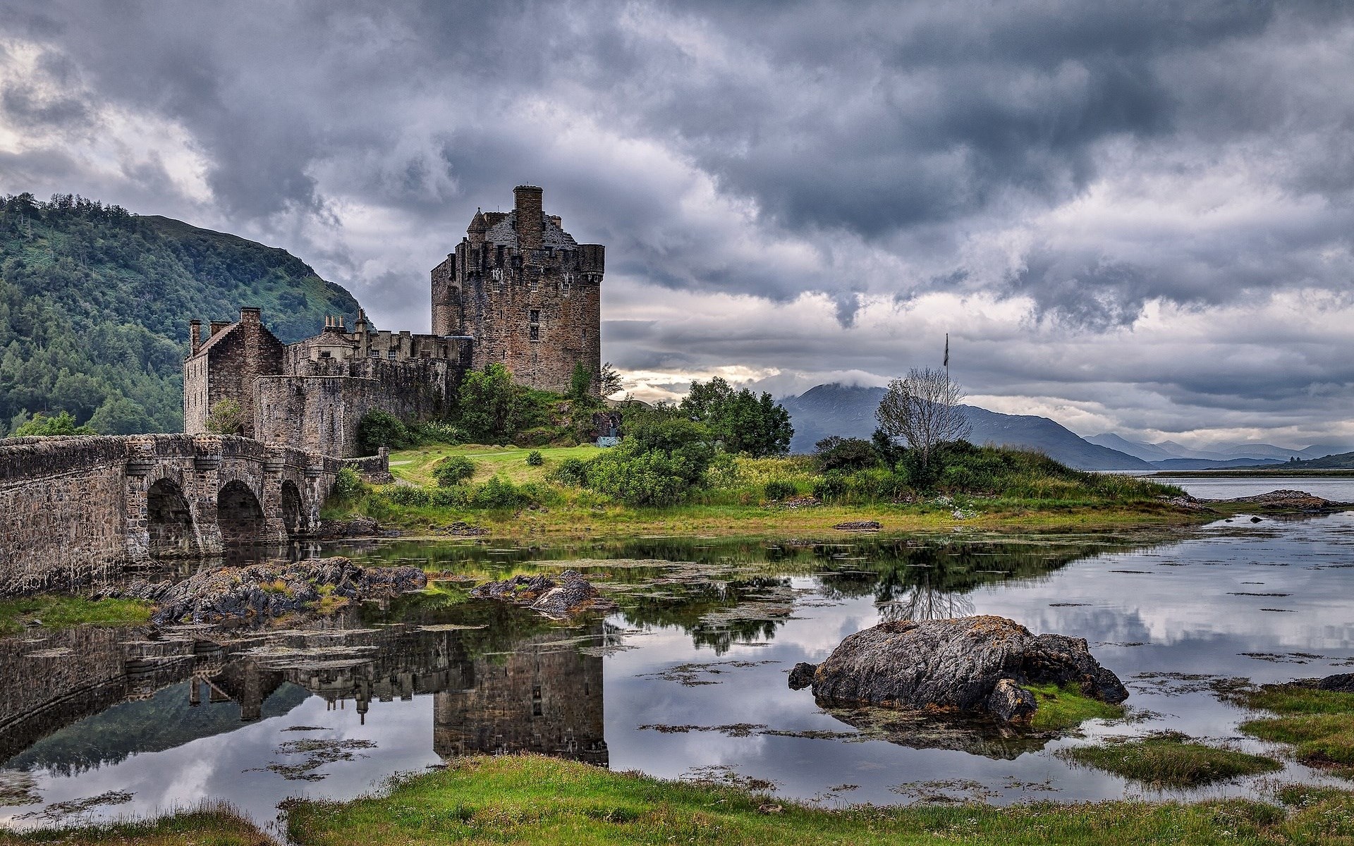 Eilean Donan Castle reflected in water under cloudy sky HD Wallpaper