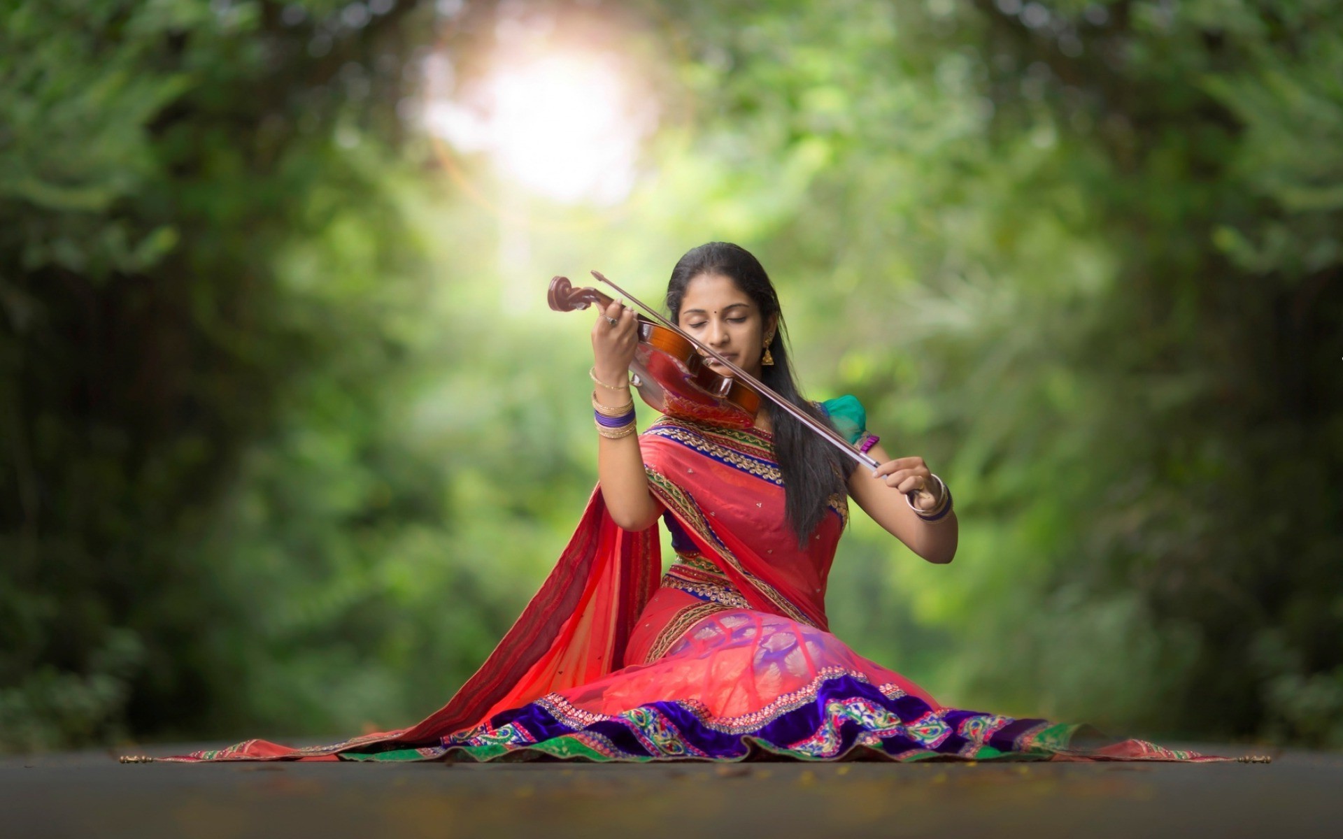 Woman playing violin in a red saree outdoors HD Wallpaper