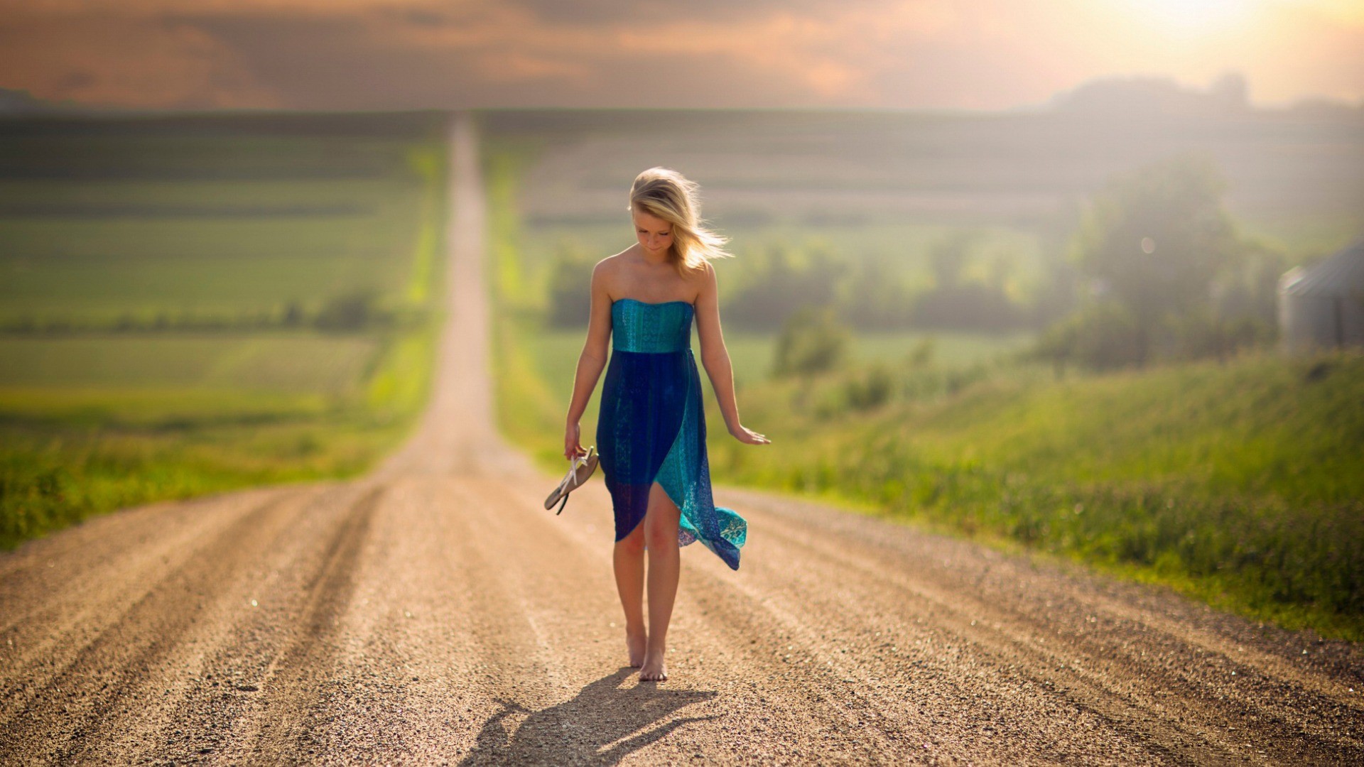 Woman in blue dress walking on a dirt road in Nebraska HD Wallpaper