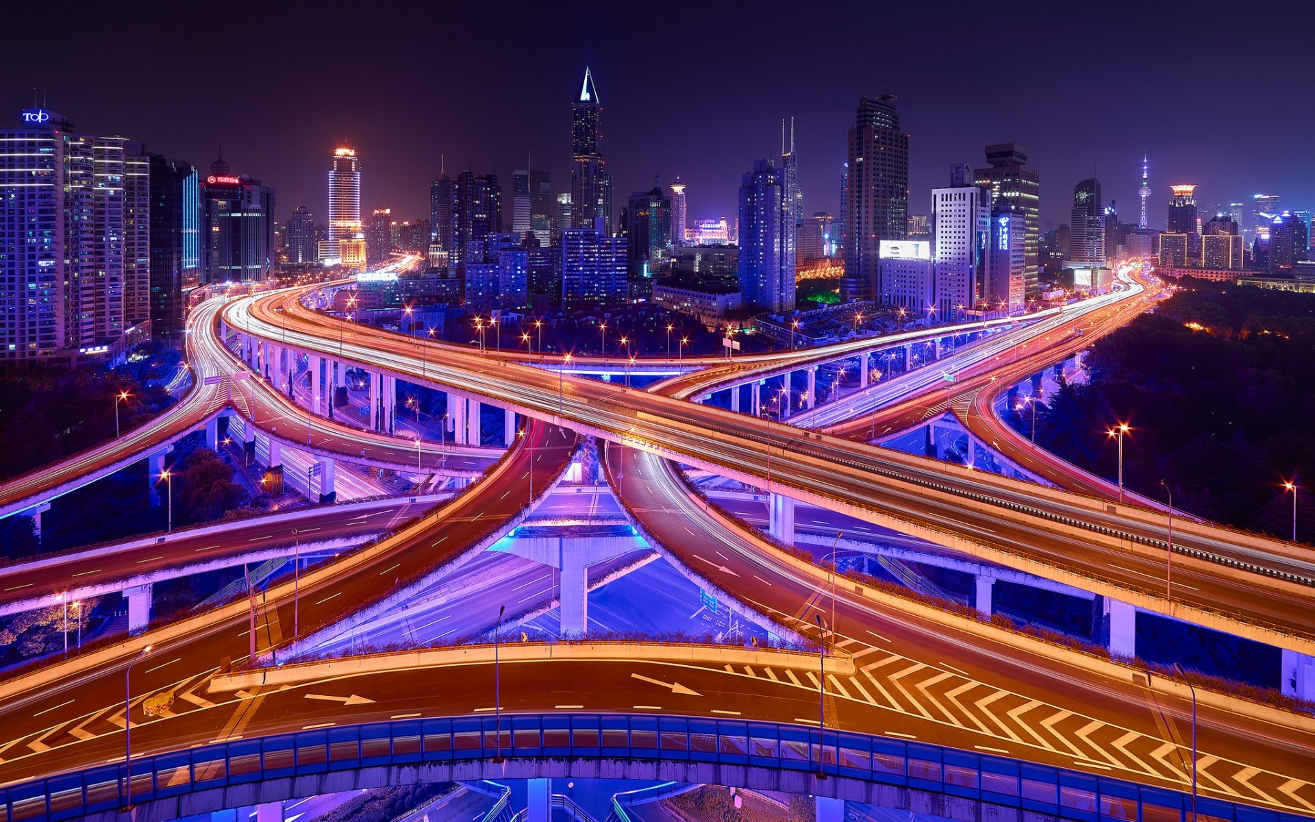 City highway interchange at night with light trails HD Wallpaper