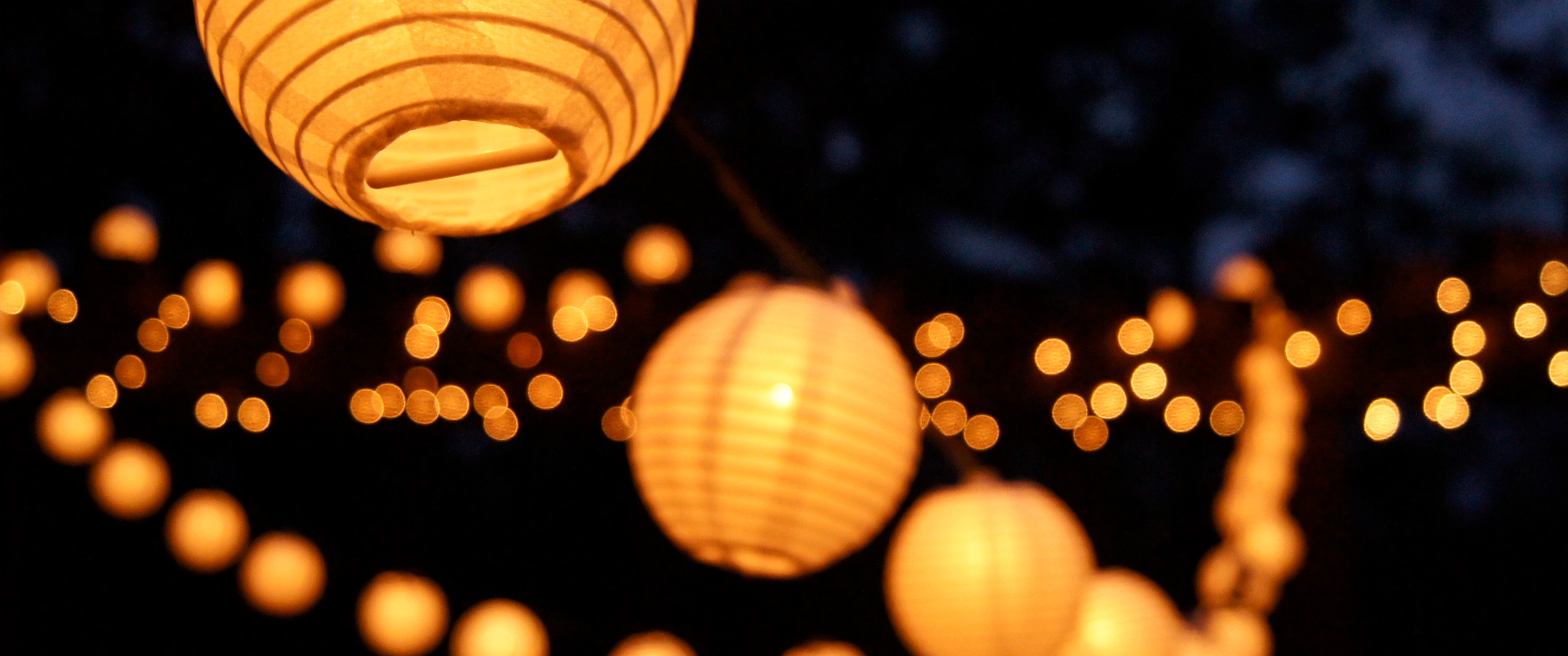 Orange paper lanterns strung together at night HD Wallpaper
