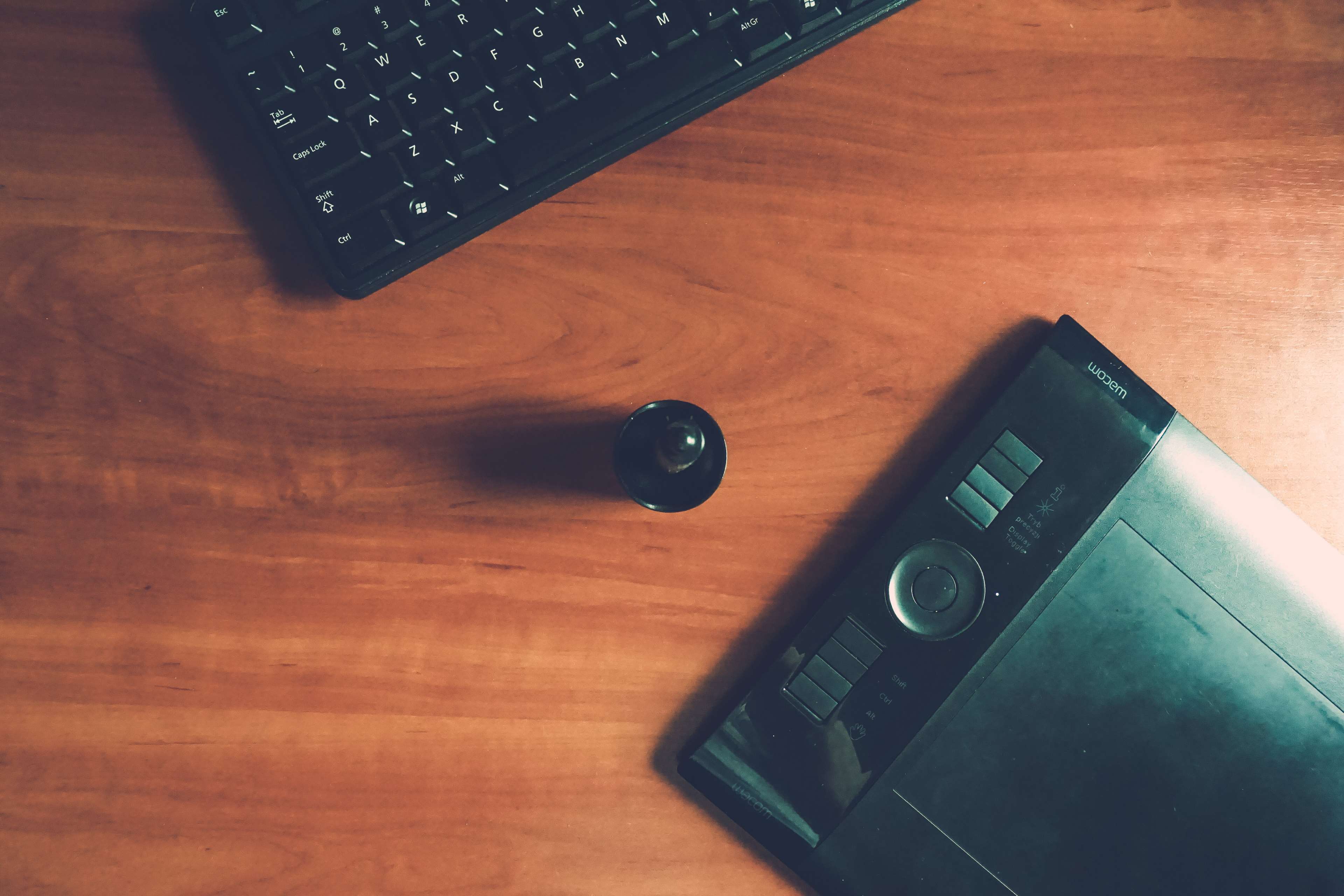 Wacom tablet and keyboard on a wooden desk HD Wallpaper