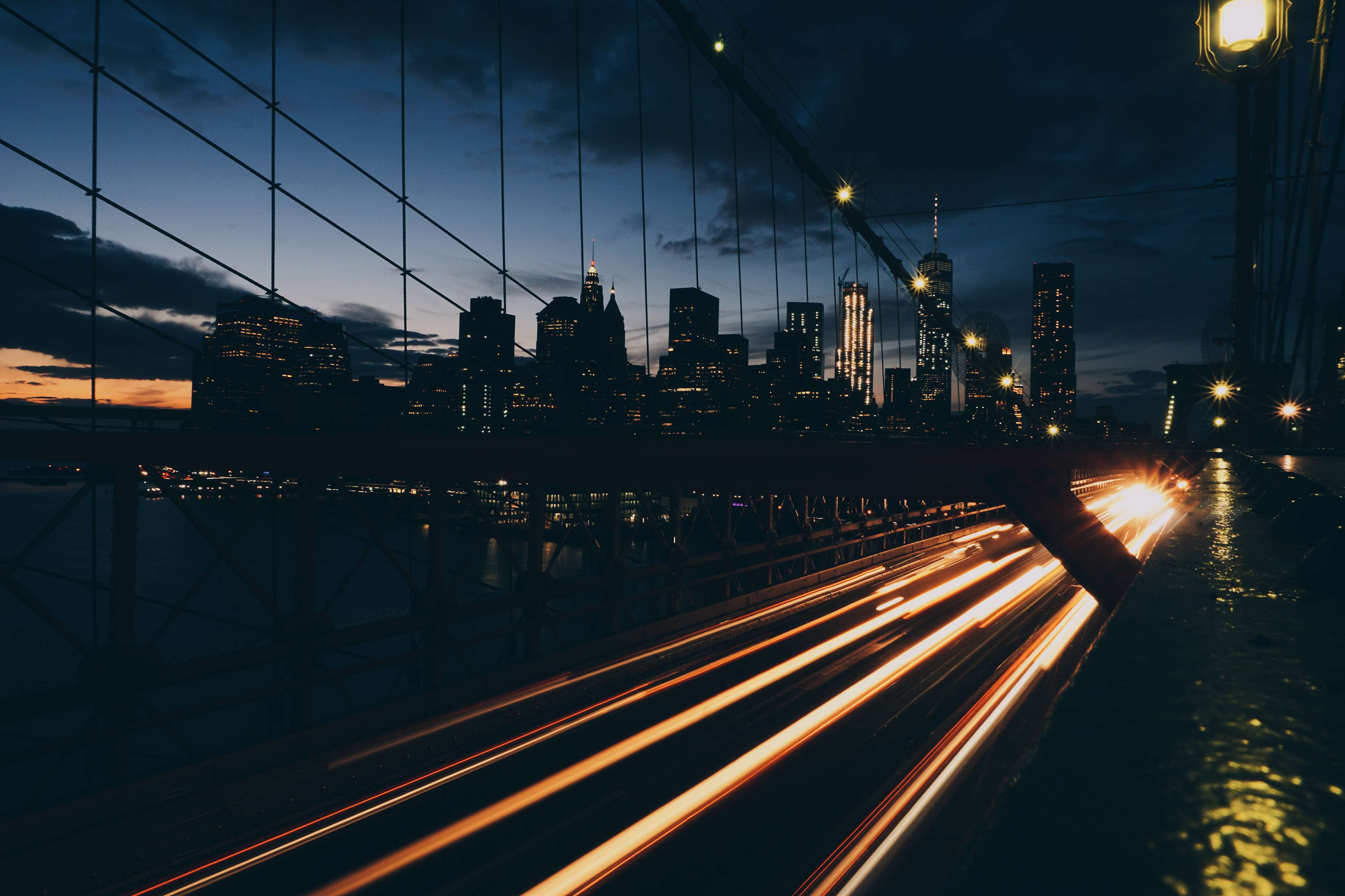 New York City skyline at night from a bridge with light trails HD Wallpaper