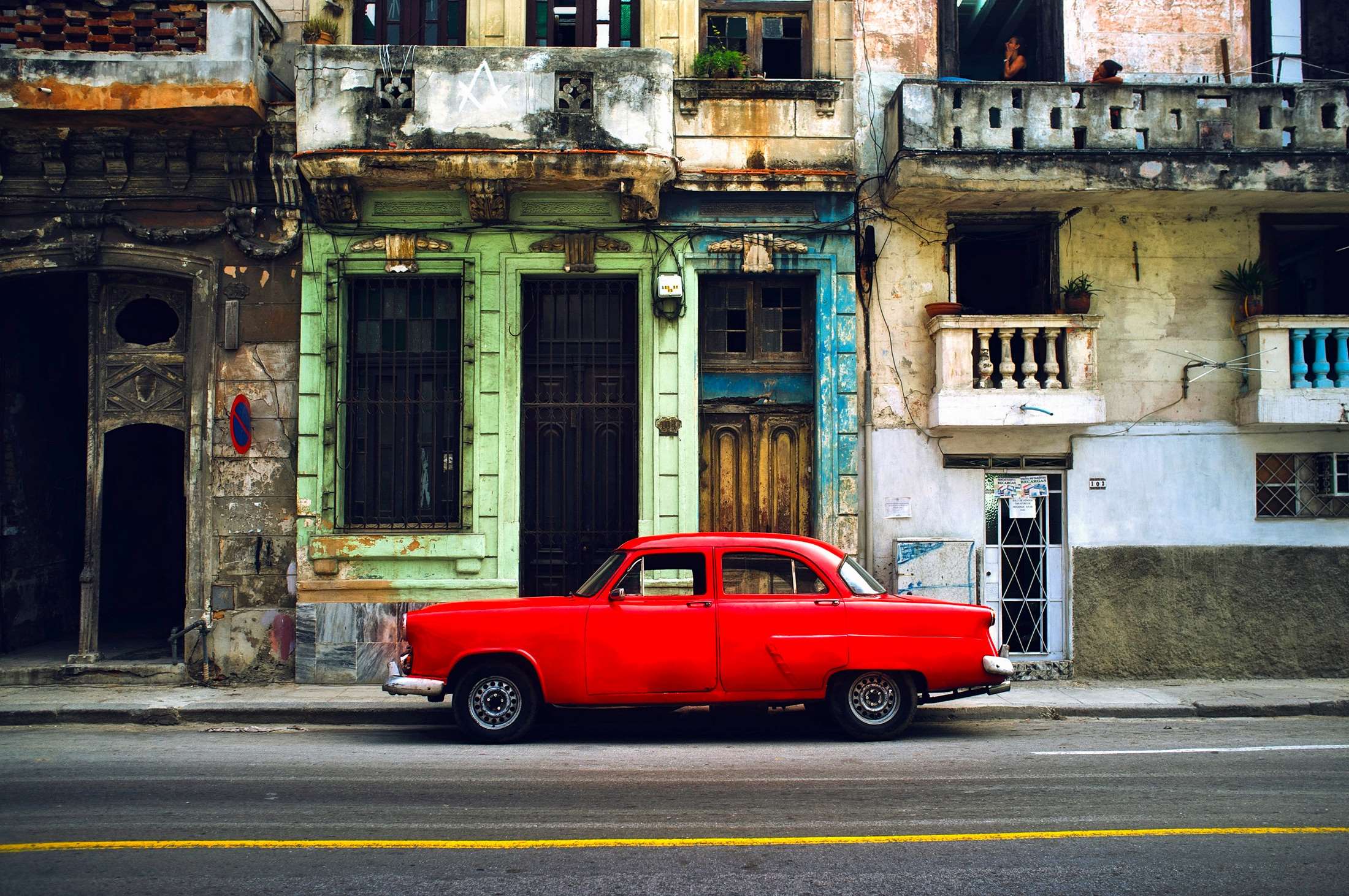 Red vintage car parked on a street in Havana, Cuba HD Wallpaper