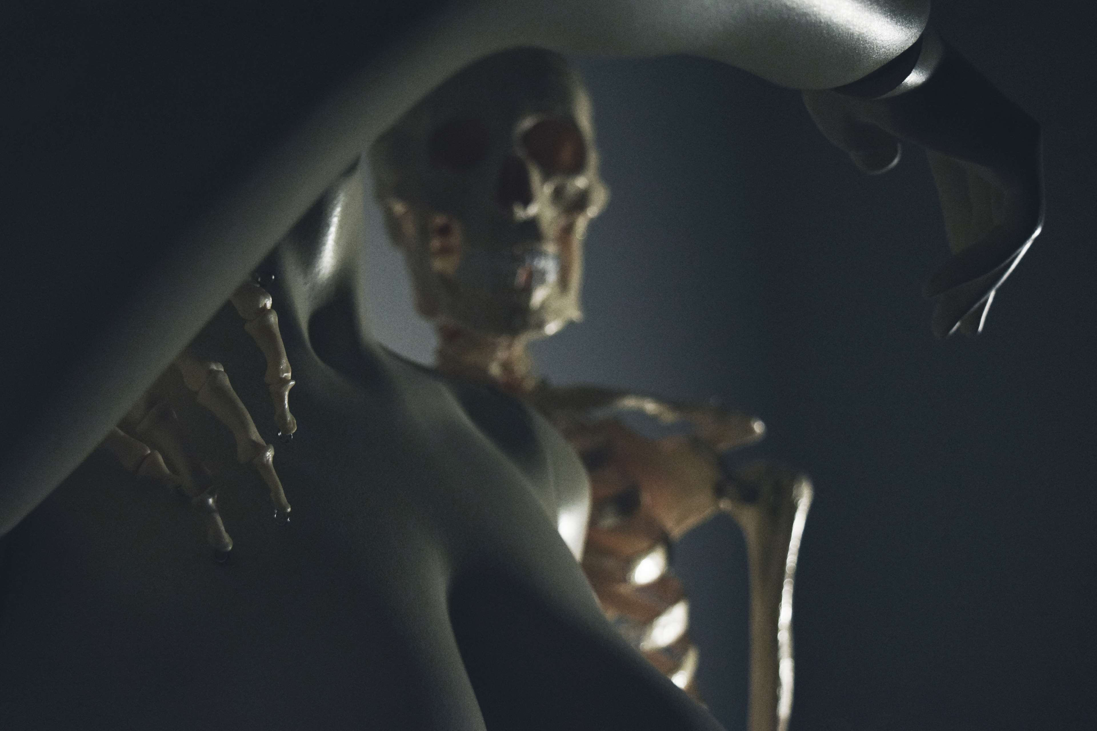 Skeleton model with robotic arm in dark lighting HD Wallpaper