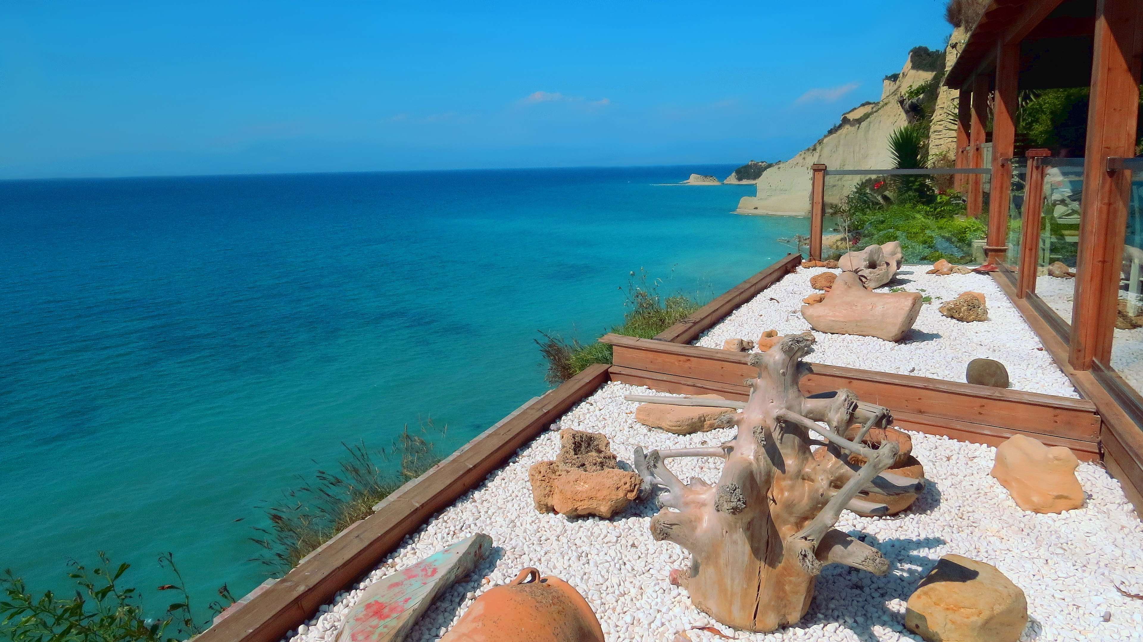 View of Cape Drastis cliffs and Ionian Sea from a terrace in Corfu, Greece HD Wallpaper
