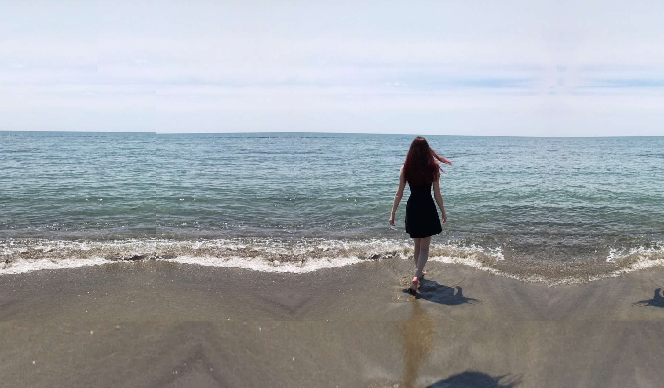 Woman in black dress walking on a beach towards the ocean HD Wallpaper