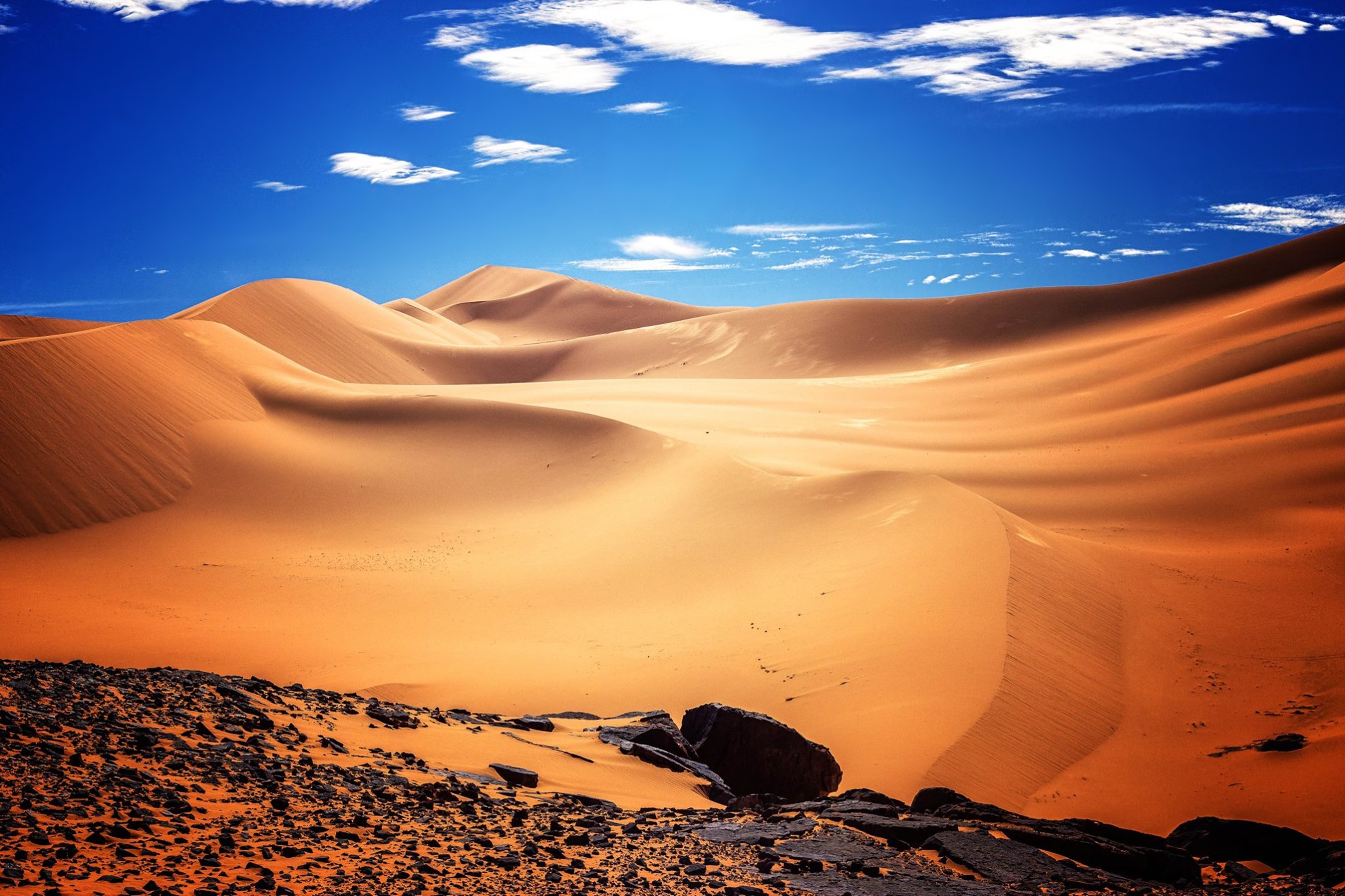 Desert dunes and rocks under a blue sky HD Wallpaper