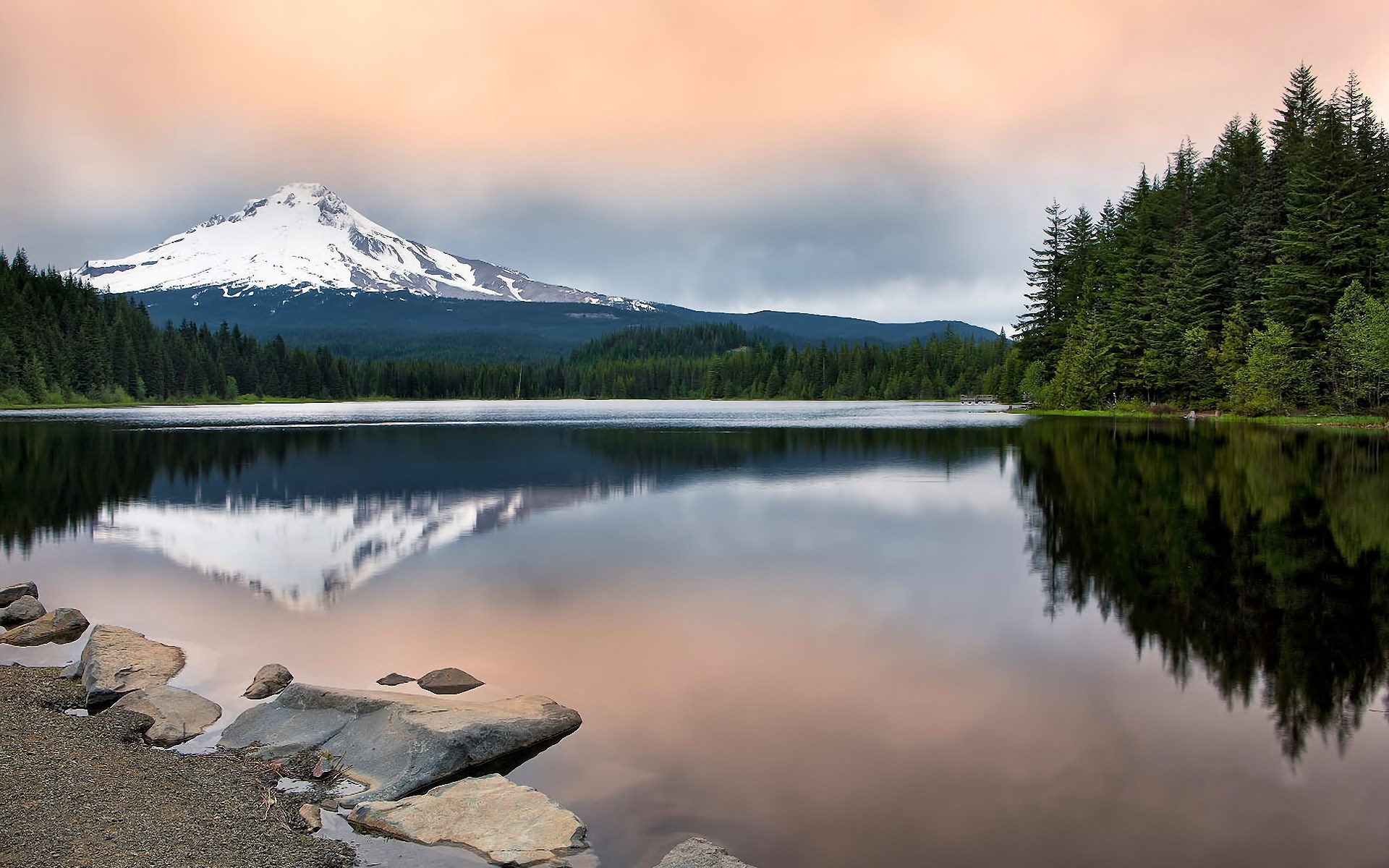 Snow-capped mountain reflected in a lake with pine trees HD Wallpaper