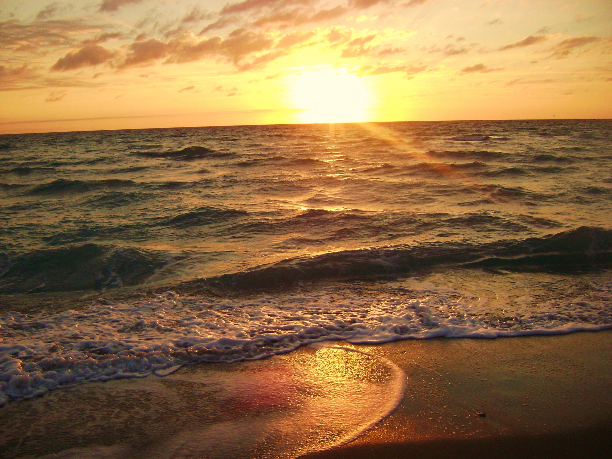 Sunset over the ocean with waves on the beach HD Wallpaper