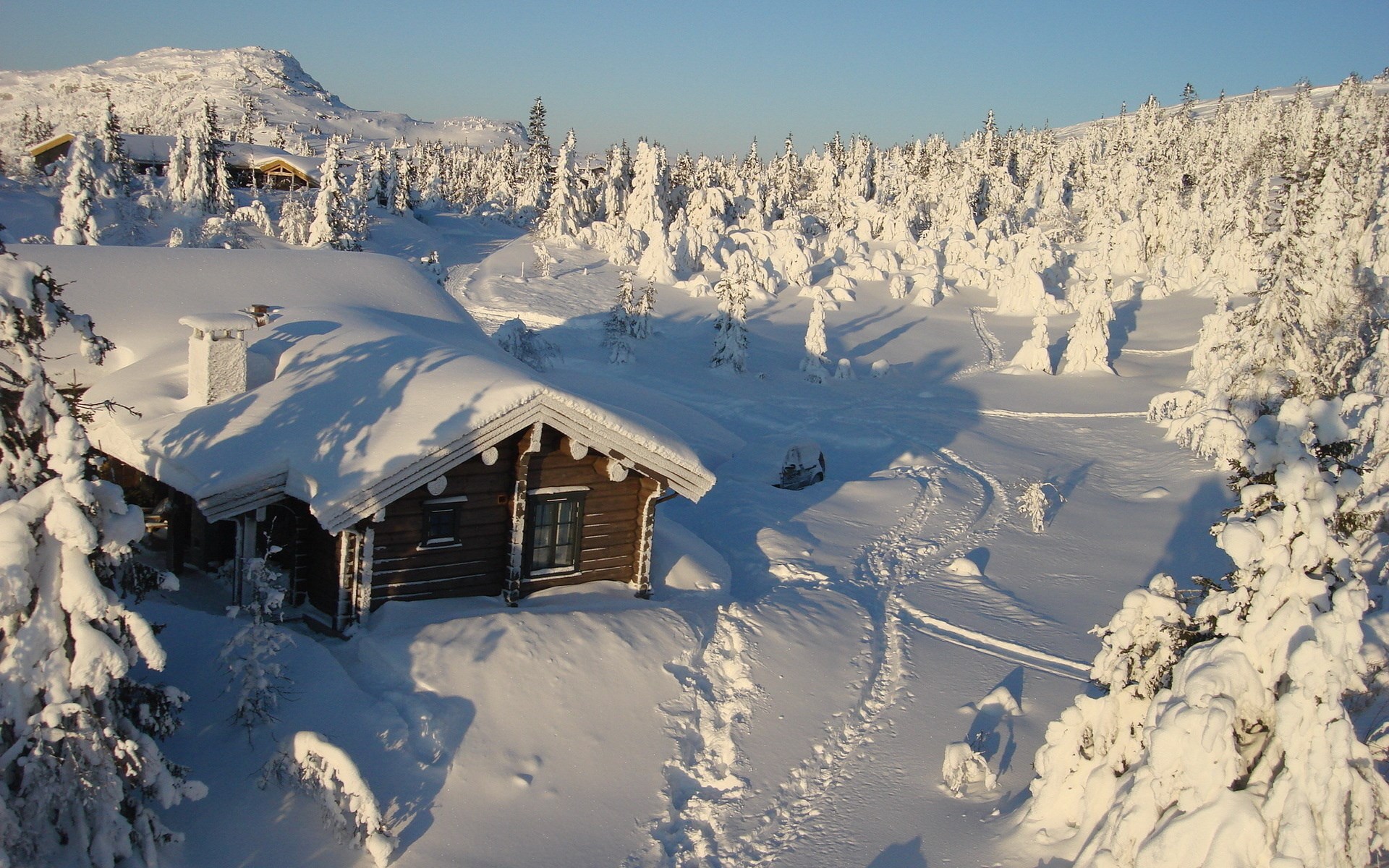 Snowy cabin in a winter forest with a snowmobile HD Wallpaper