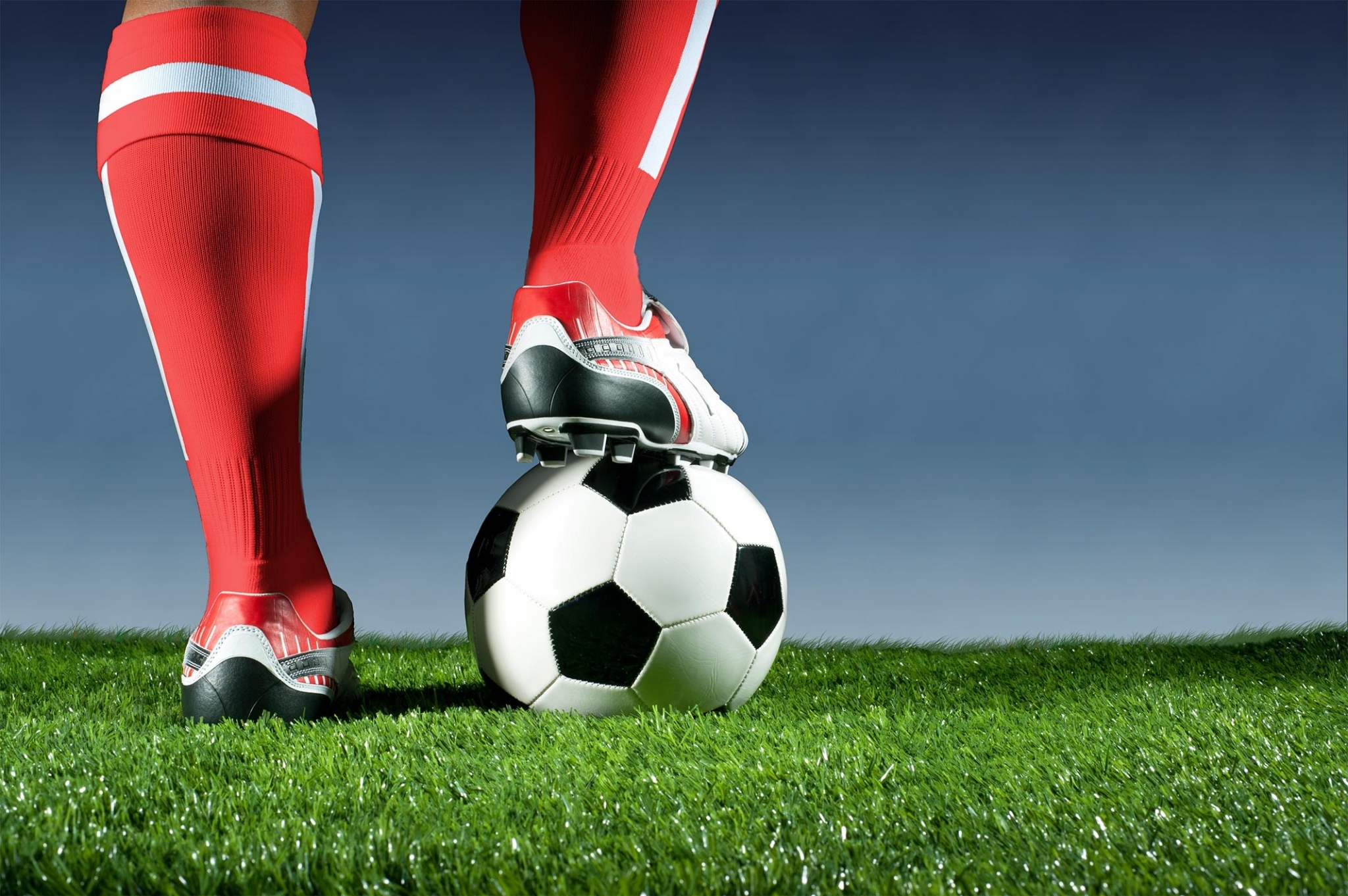 Soccer ball with player's foot on grass HD Wallpaper