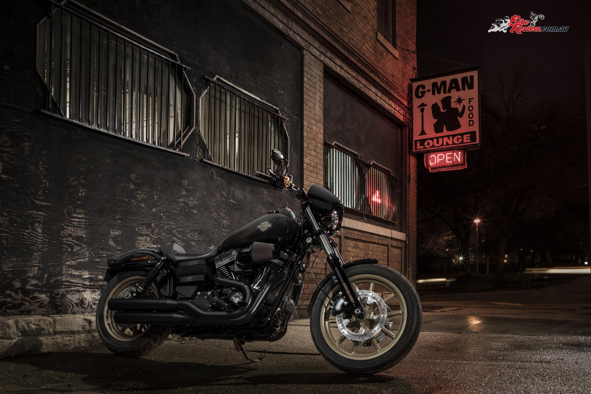 Harley Davidson motorcycle parked outside G-Man Lounge at night HD Wallpaper