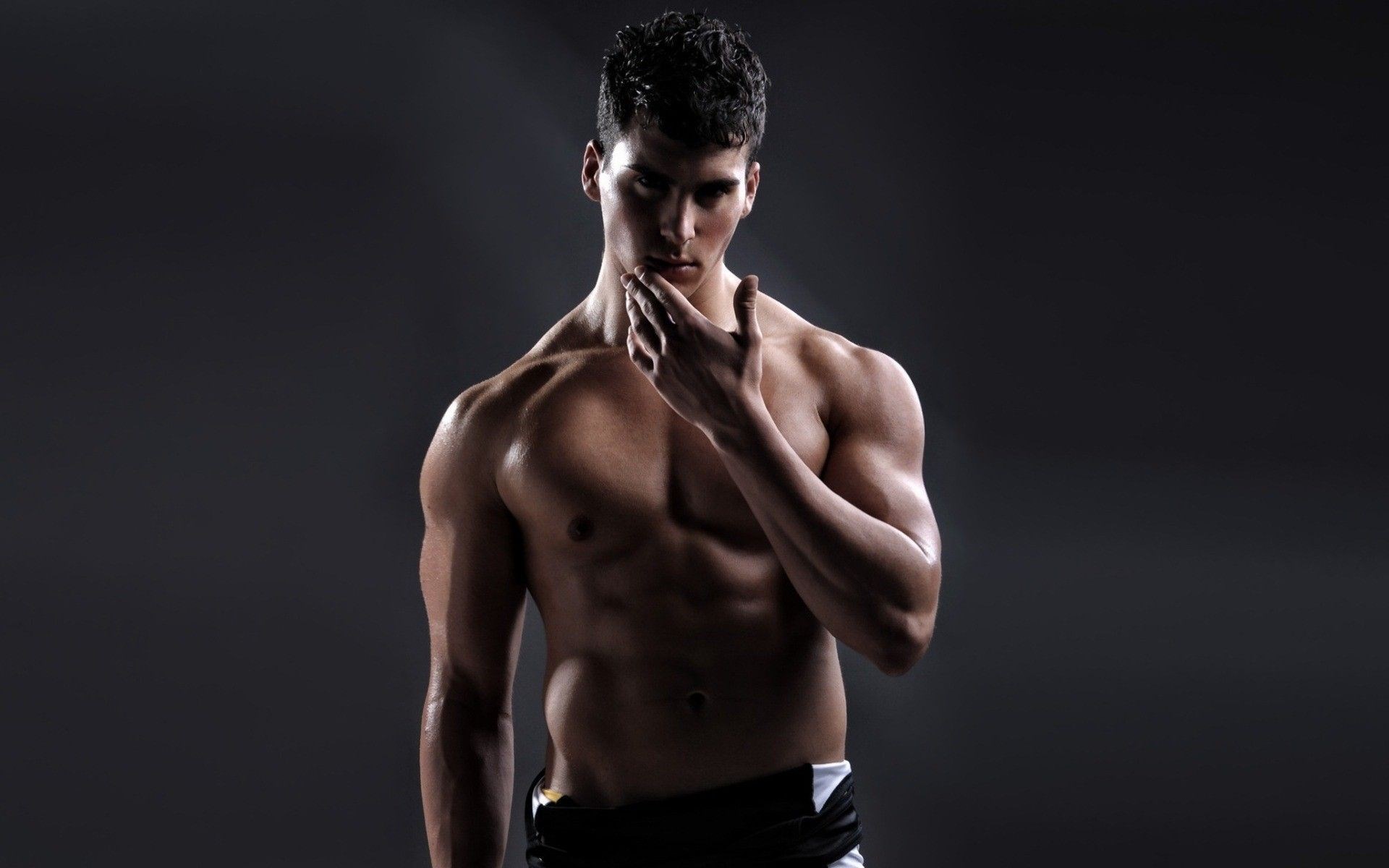 Muscular man posing in studio HD Wallpaper