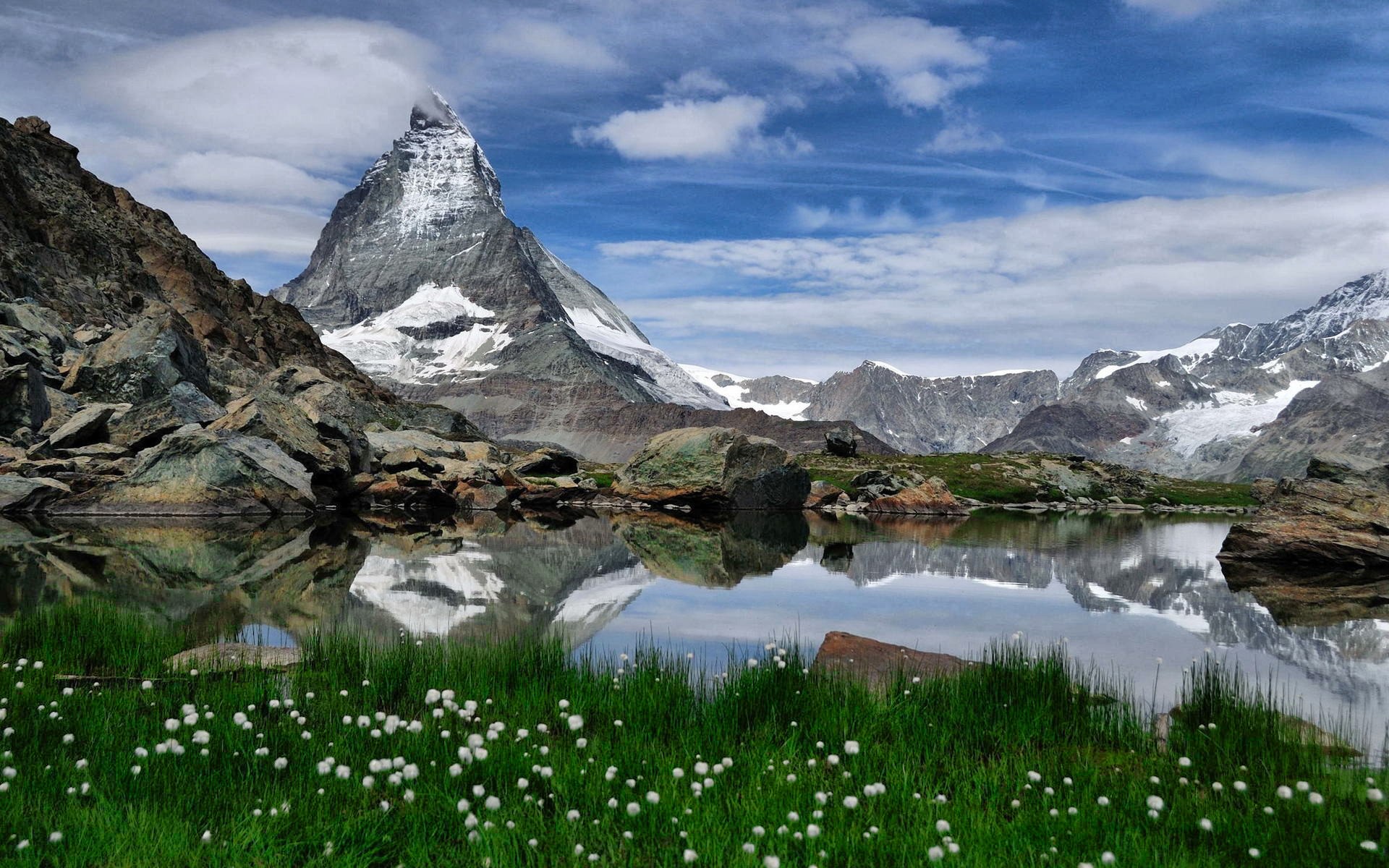Matterhorn reflected in a mountain lake with flowers HD Wallpaper