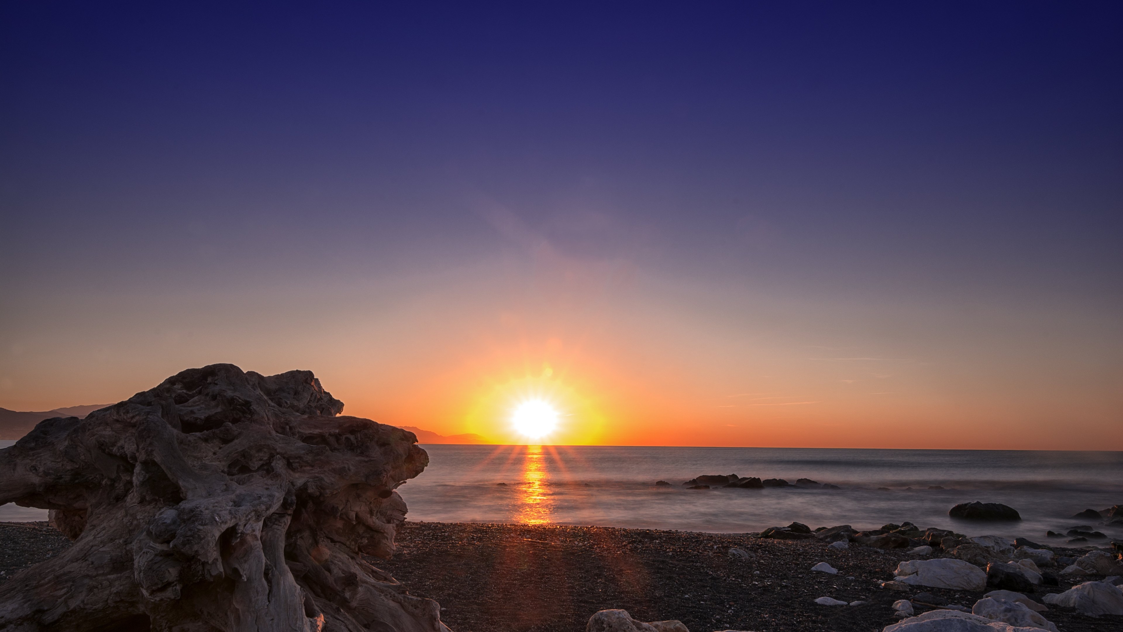 4K Sunset over the Ocean with Driftwood HD Wallpaper