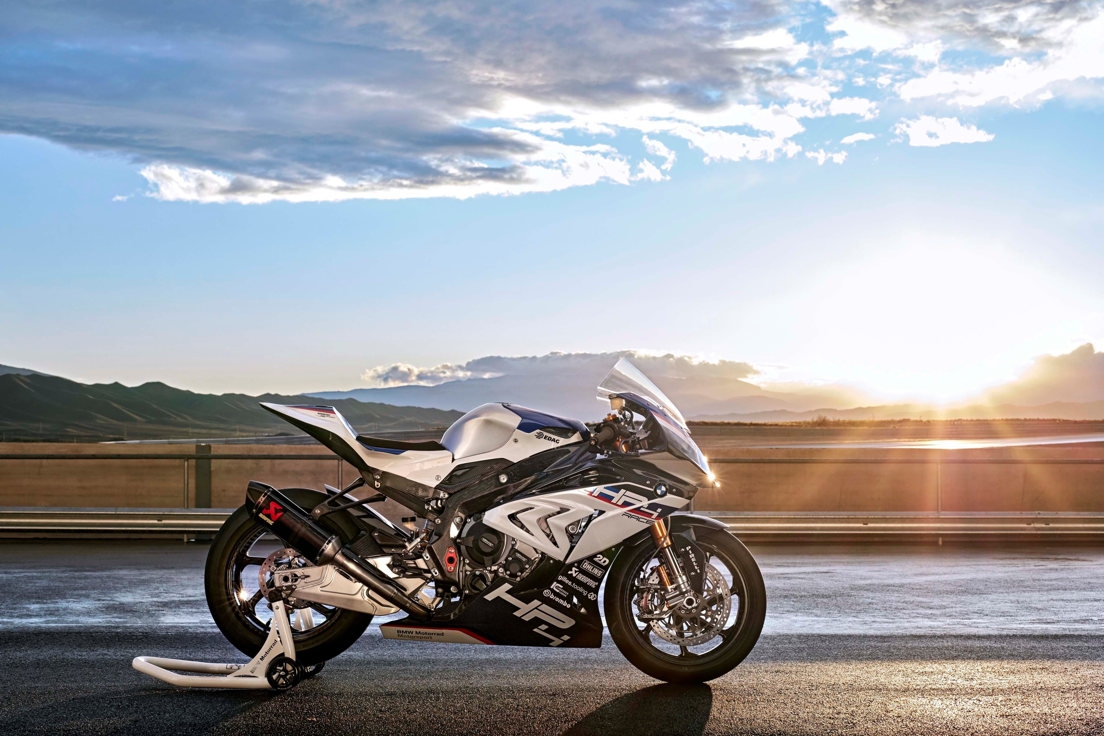 BMW HP4 Race motorcycle on a track at sunset HD Wallpaper