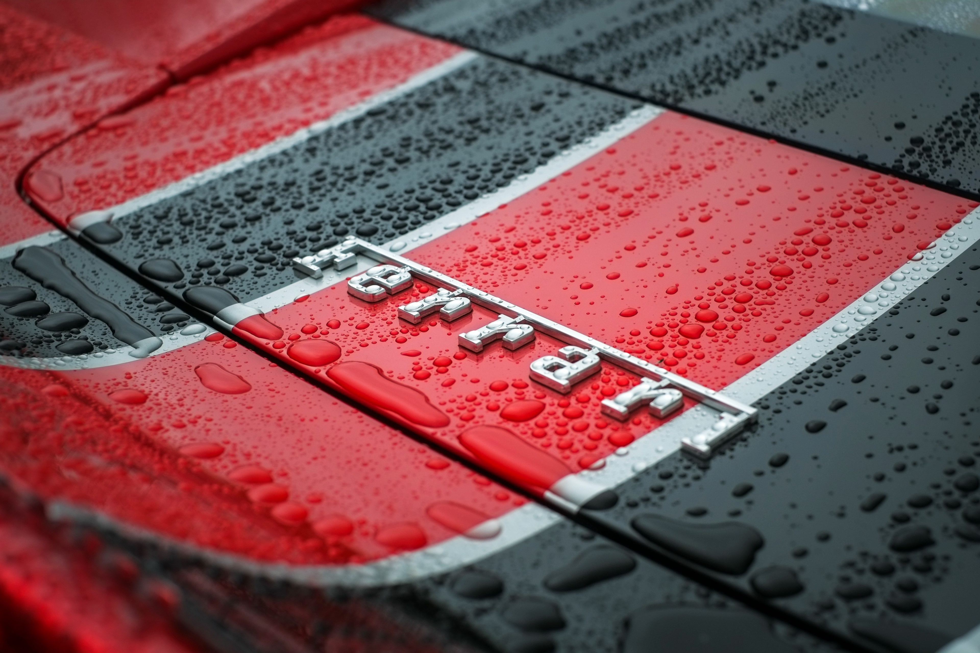 Ferrari logo on a car with water droplets HD Wallpaper