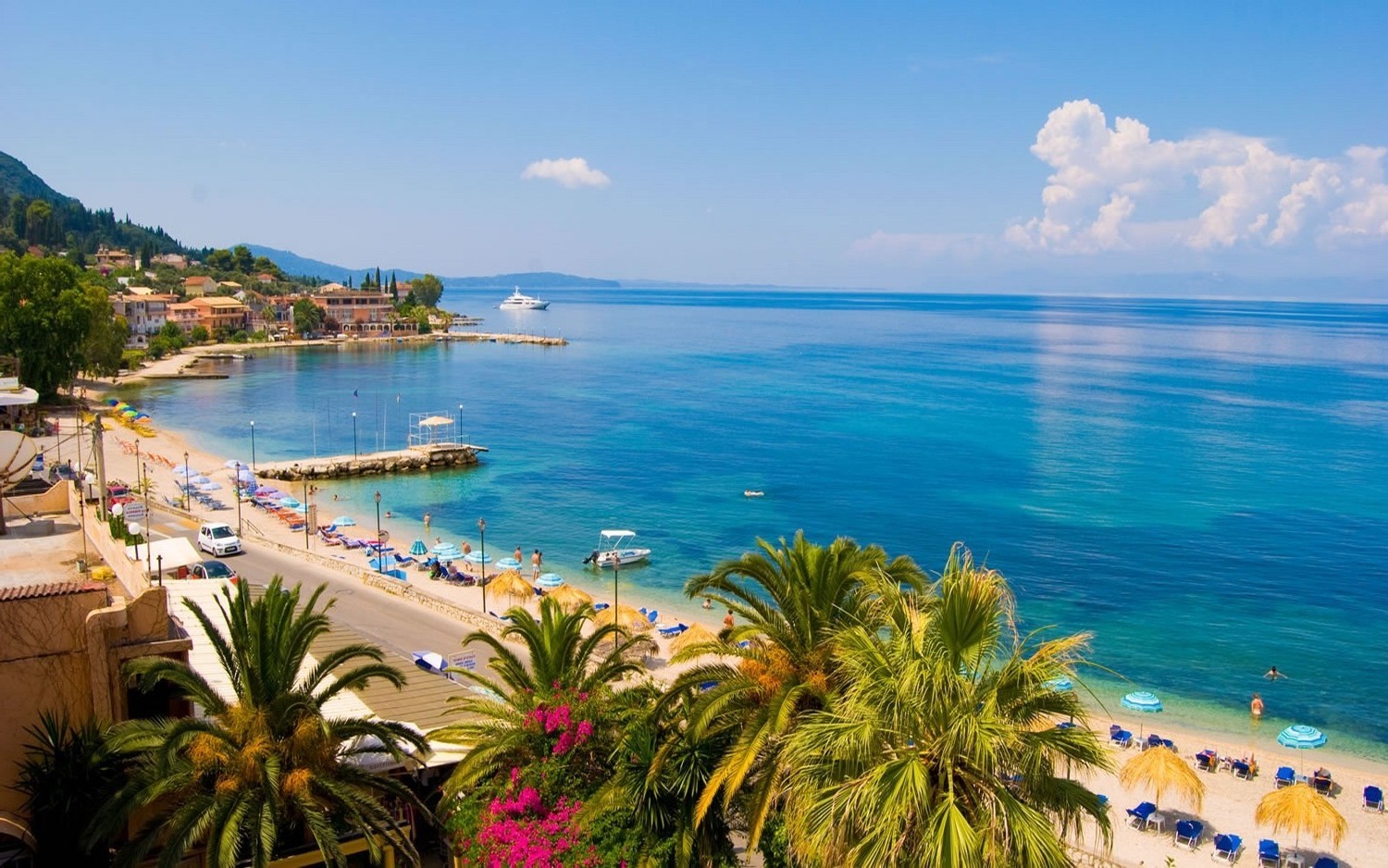 Beach town with palm trees and blue sea in Greece HD Wallpaper