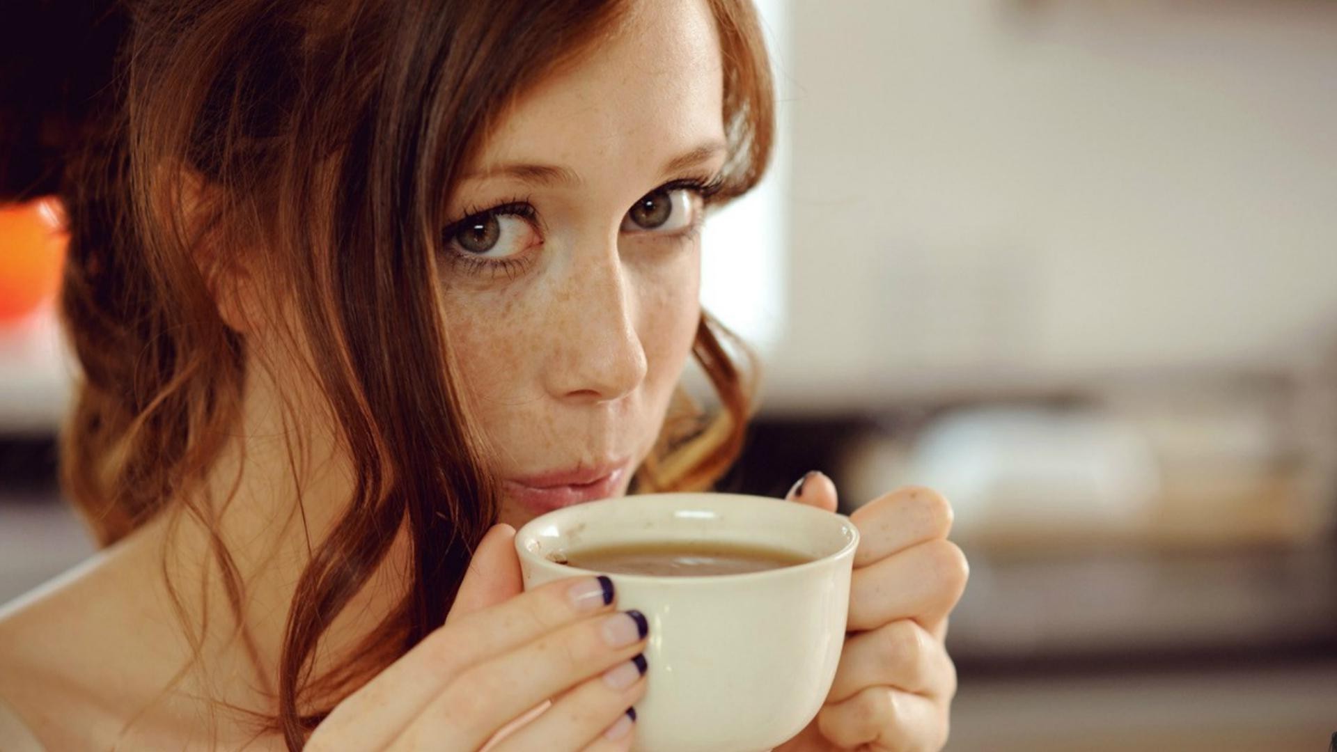 Woman with freckles drinking from a cup HD Wallpaper