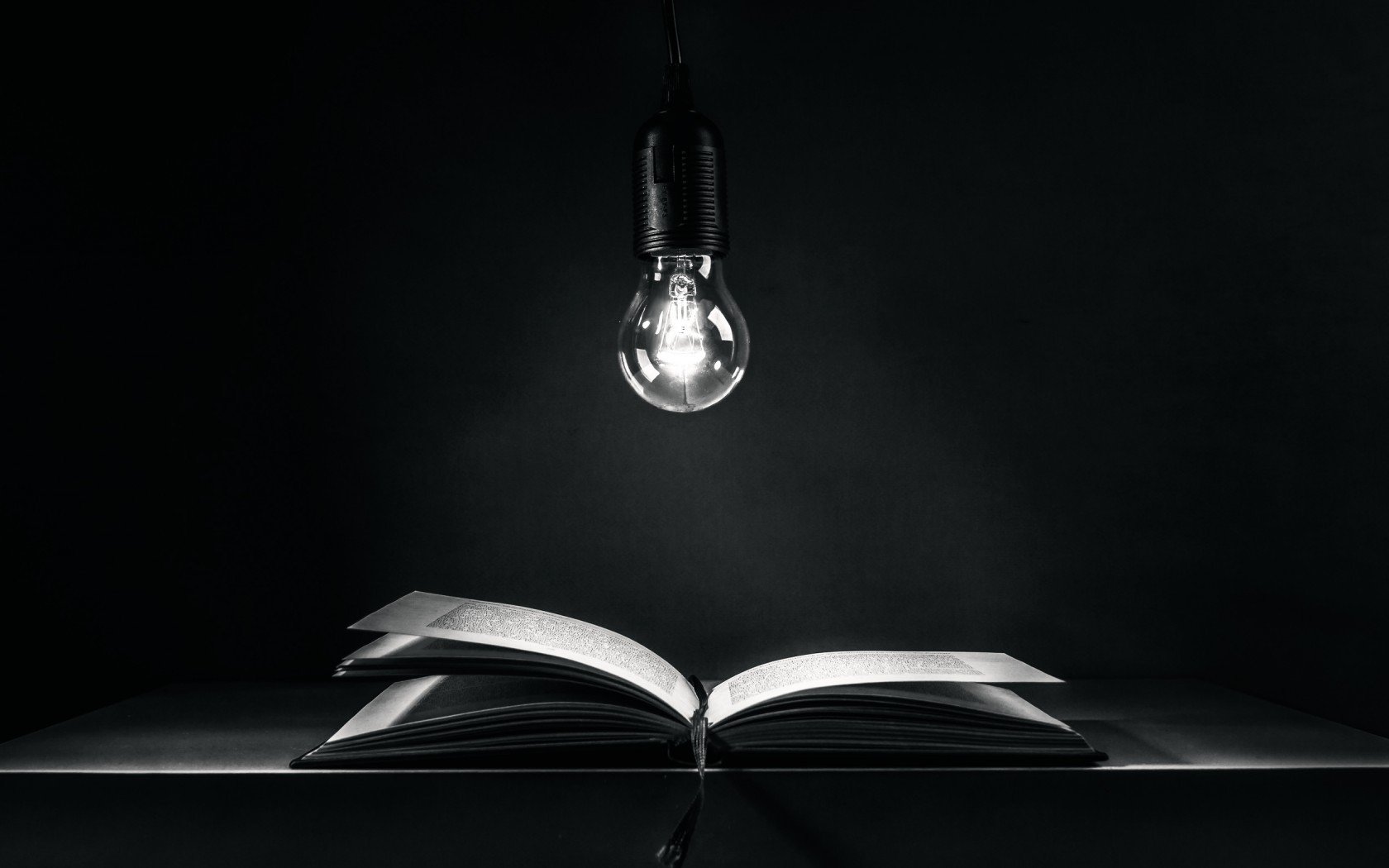Light bulb illuminating an open book HD Wallpaper