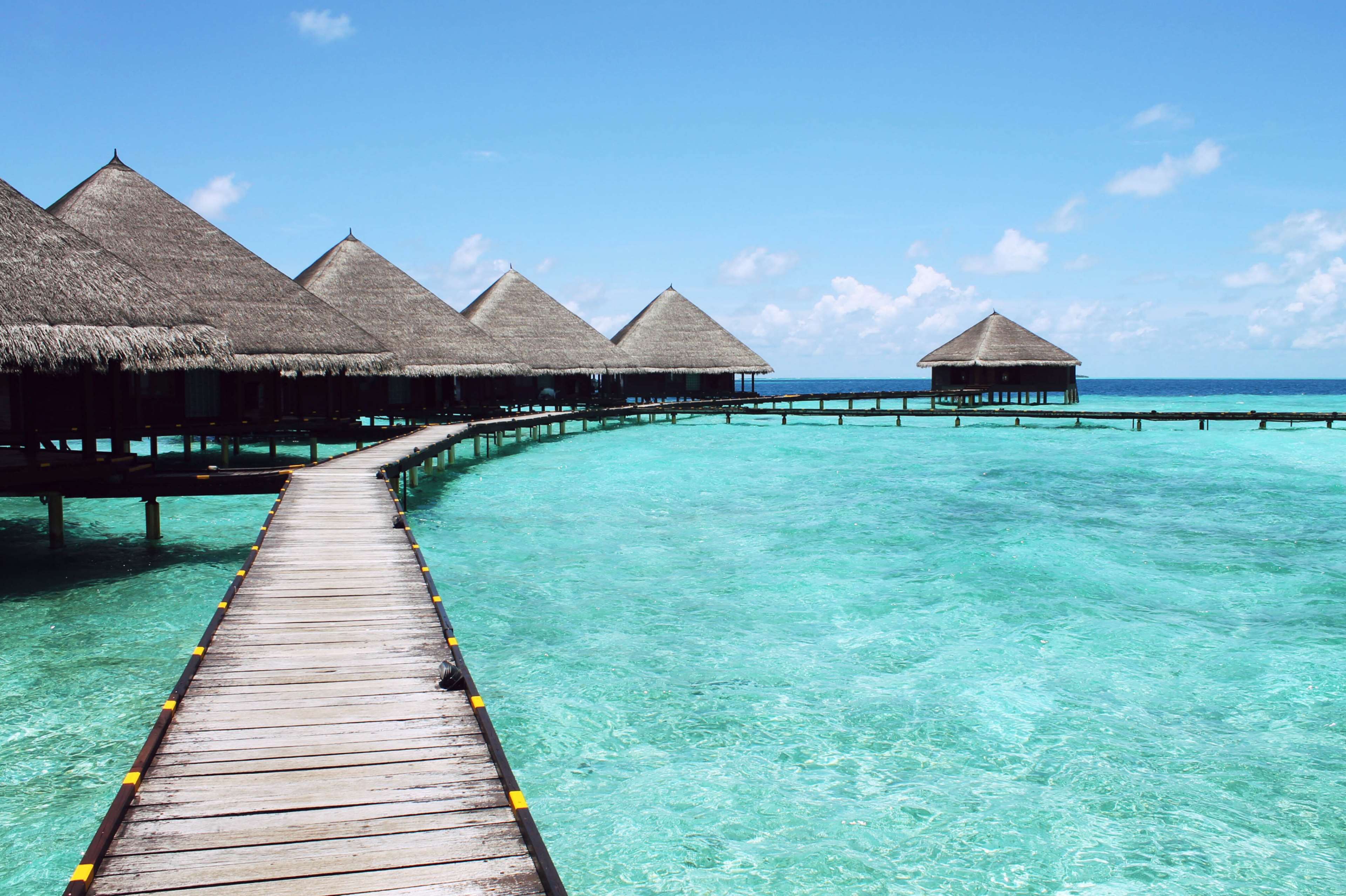 Overwater bungalows on a tropical turquoise sea HD Wallpaper