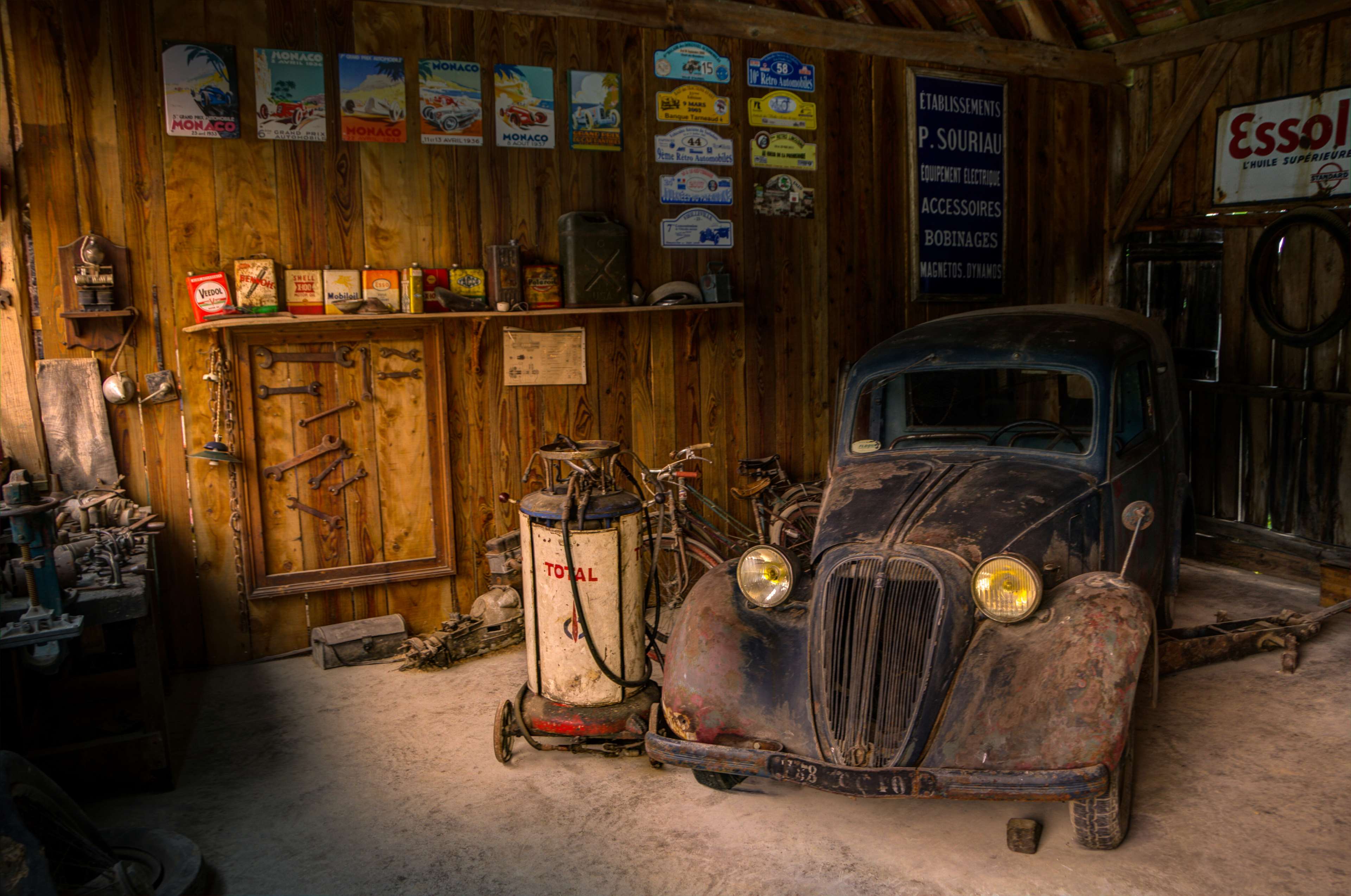 Old car in a rustic garage with vintage items HD Wallpaper
