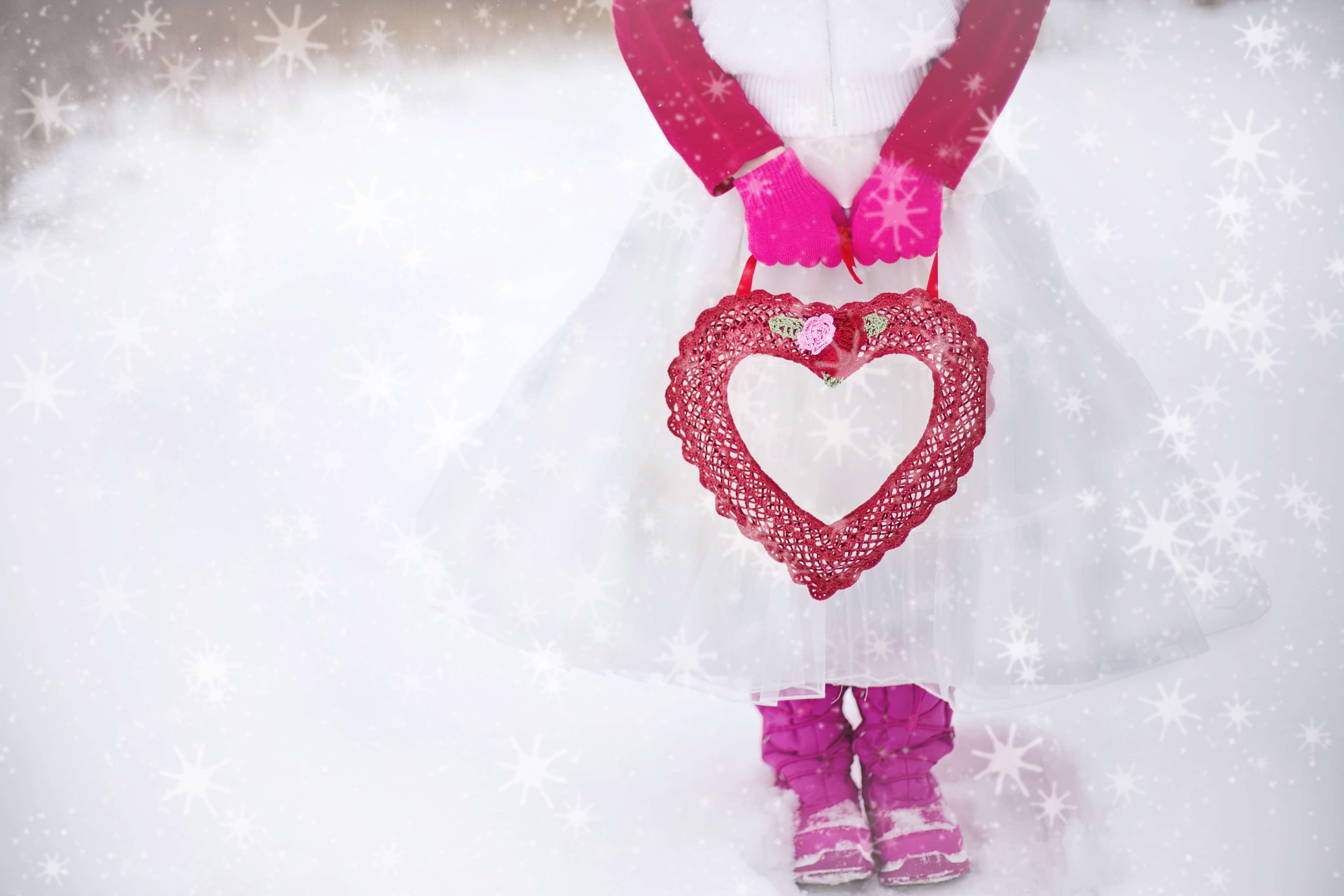 Girl in pink gloves holding a heart in winter HD Wallpaper
