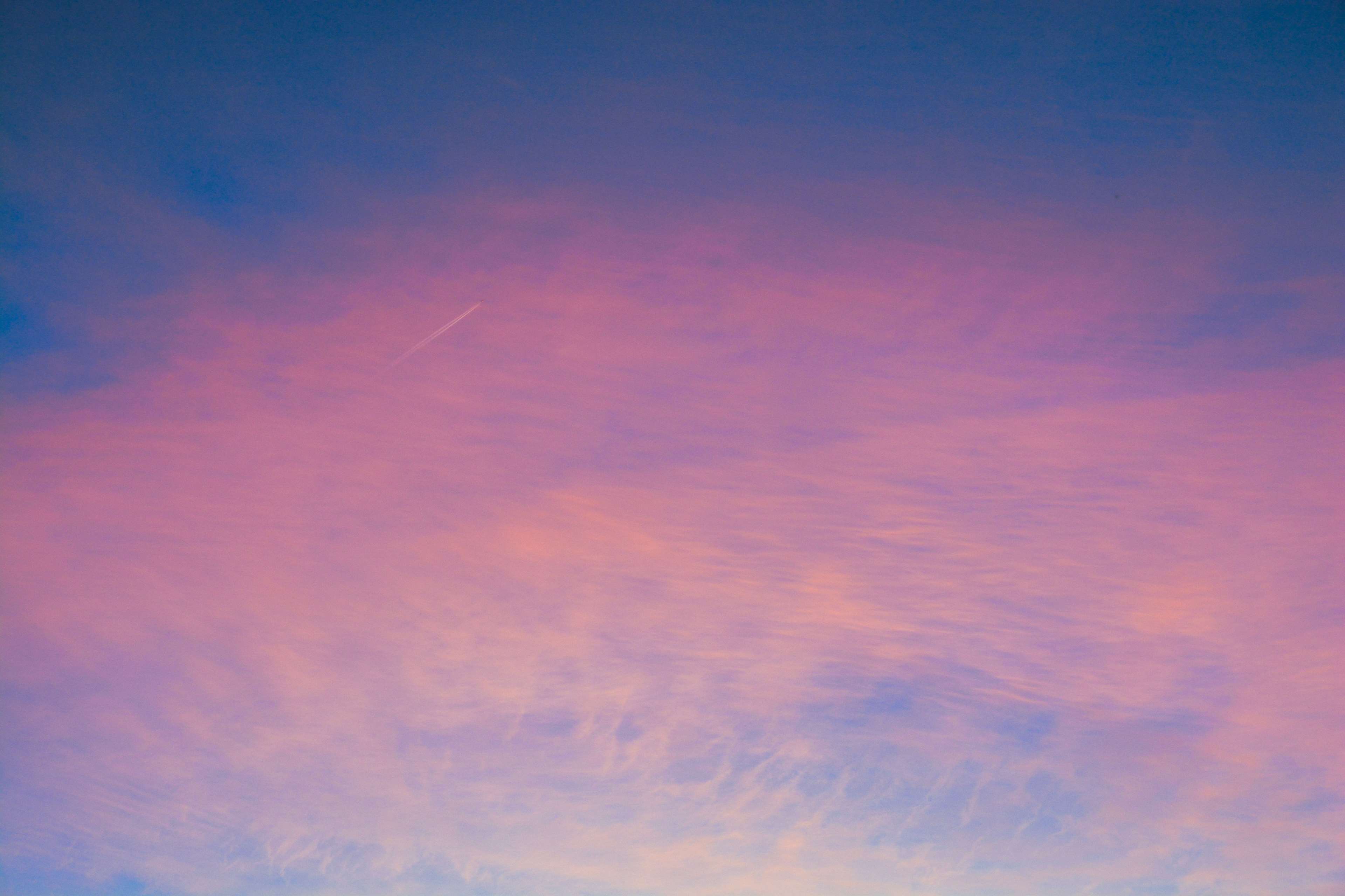 Pink and blue sky with contrail at sunset 4K HD Wallpaper