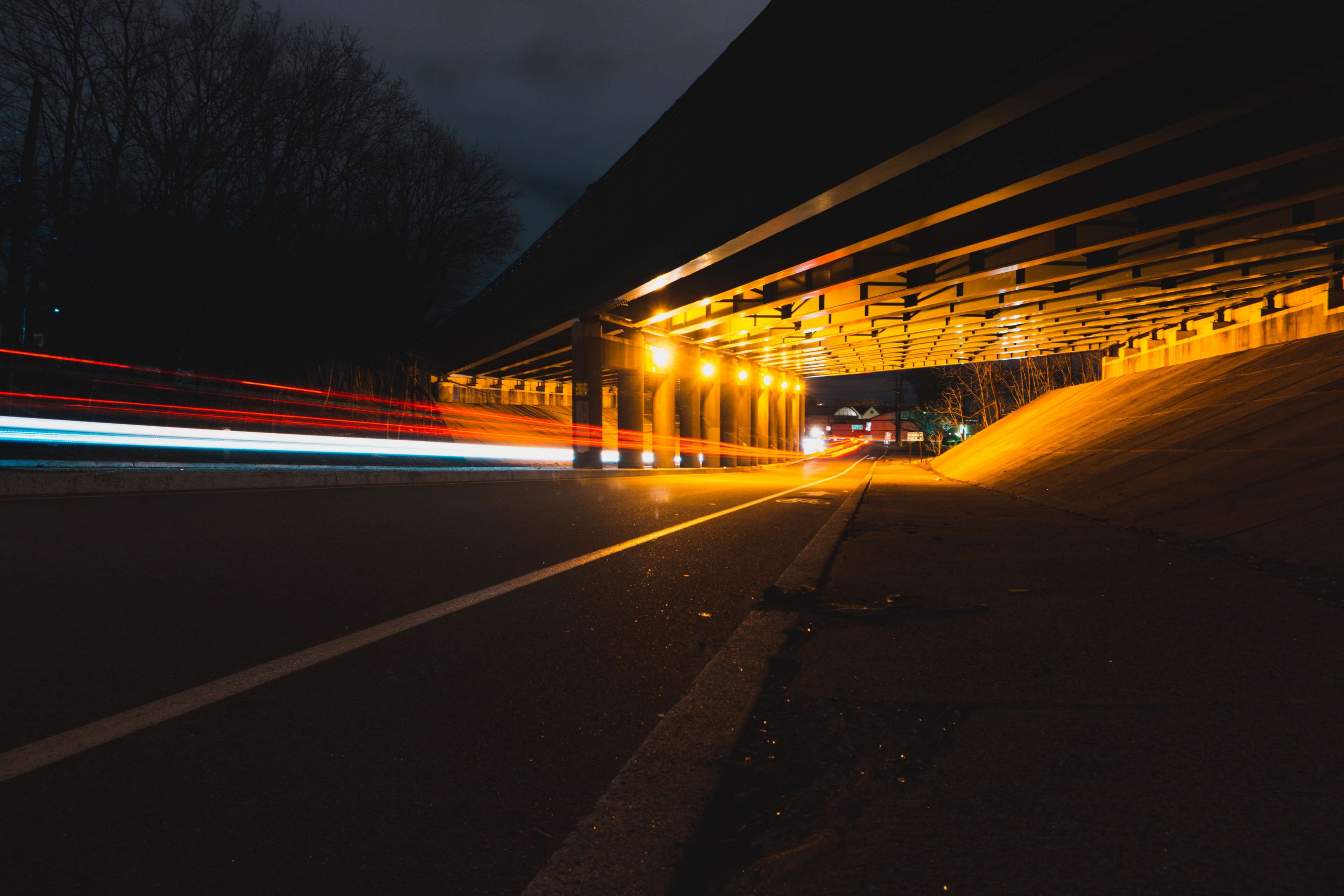 Light trails under a bridge at night HD Wallpaper