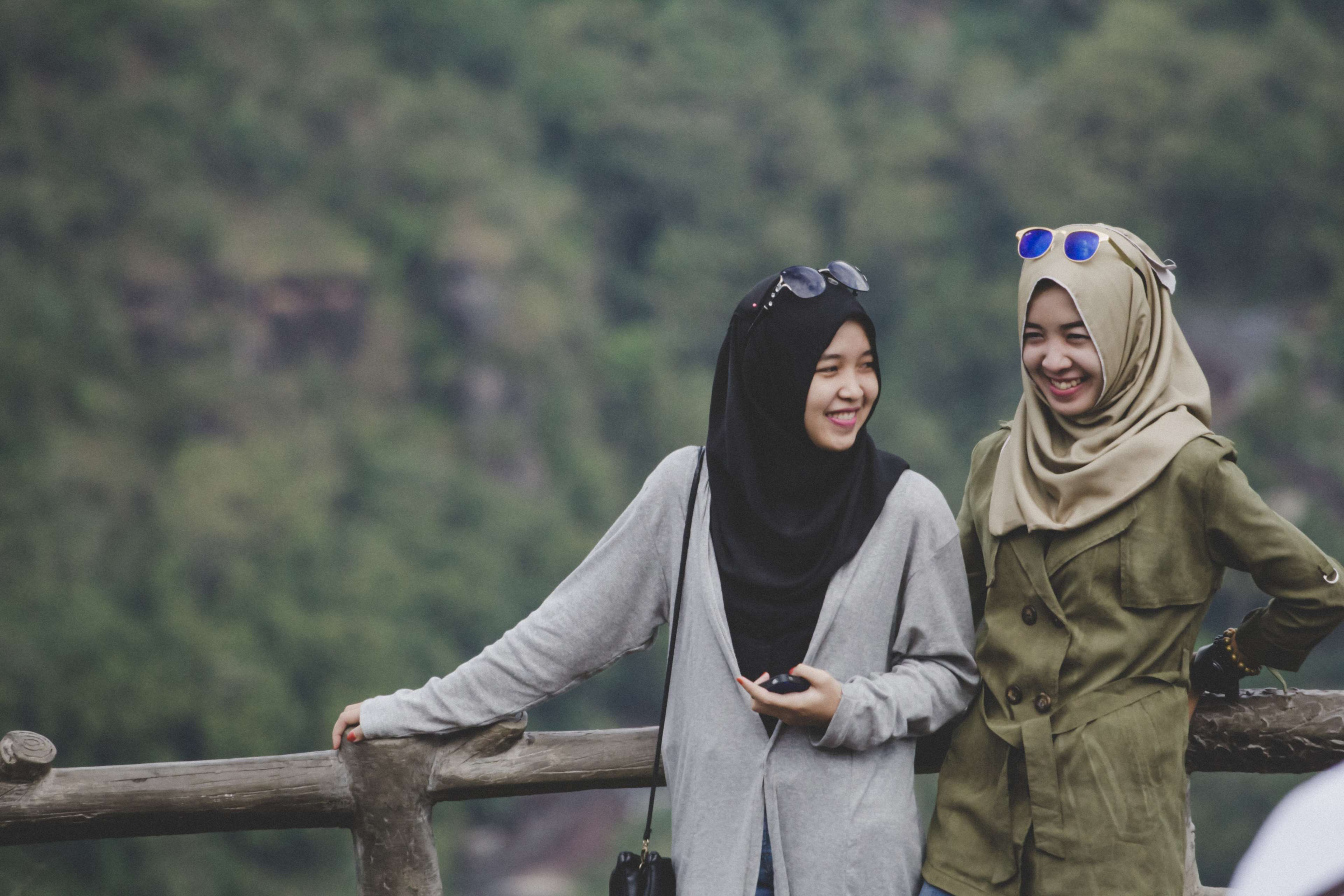 Two smiling women wearing hijabs and sunglasses HD Wallpaper