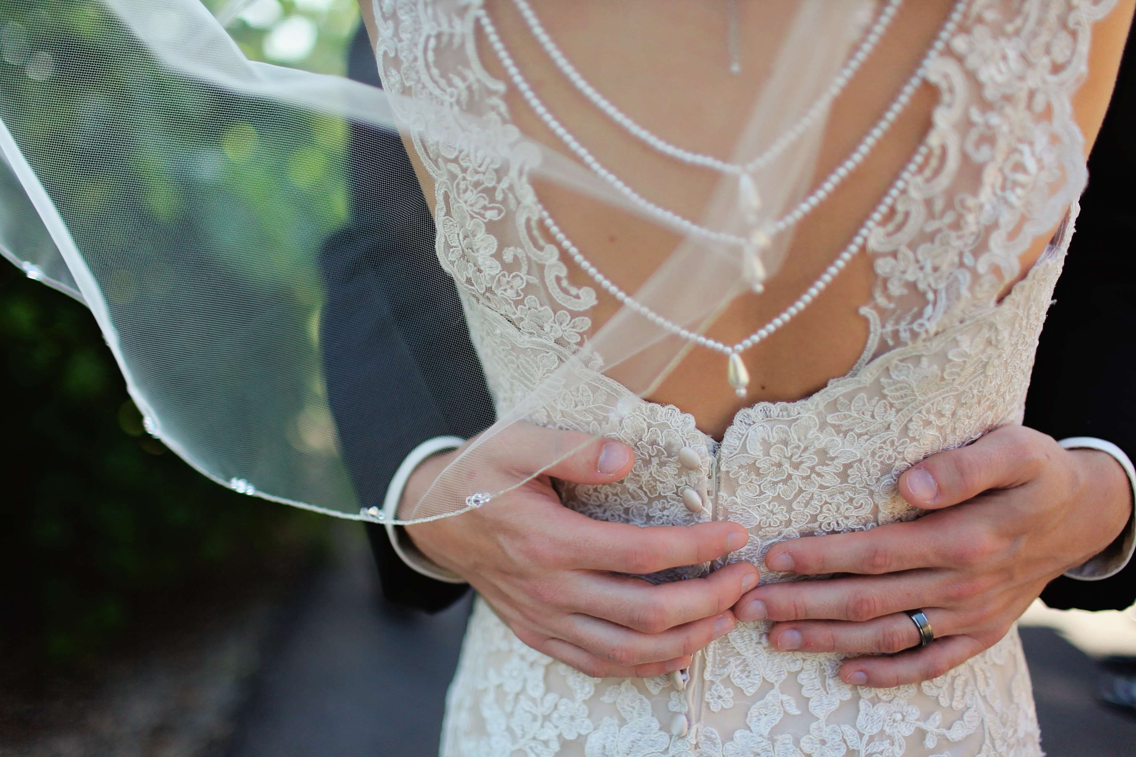 Bride and Groom embracing with lace wedding dress and veil HD Wallpaper