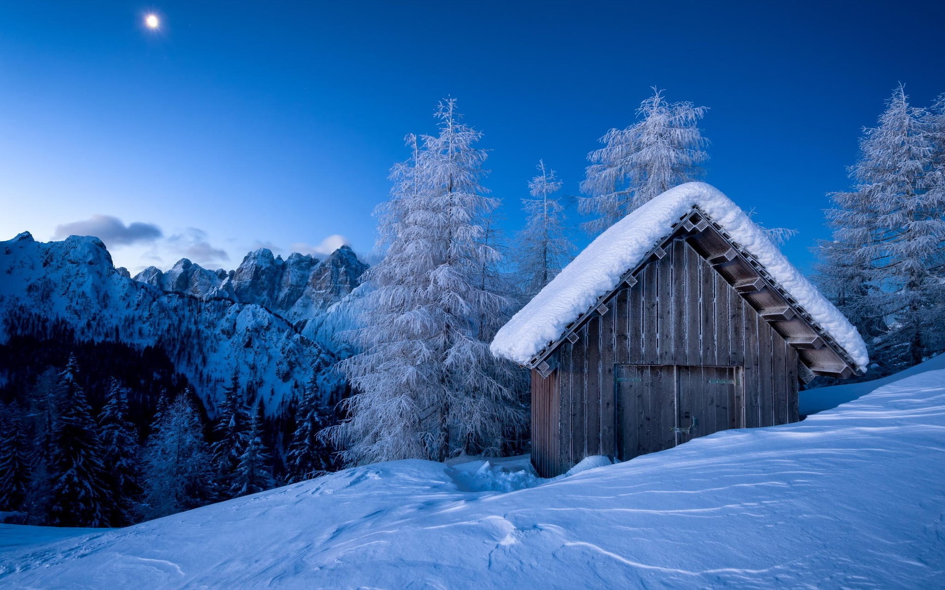 Wooden cabin in a snowy mountain landscape at dusk HD Wallpaper
