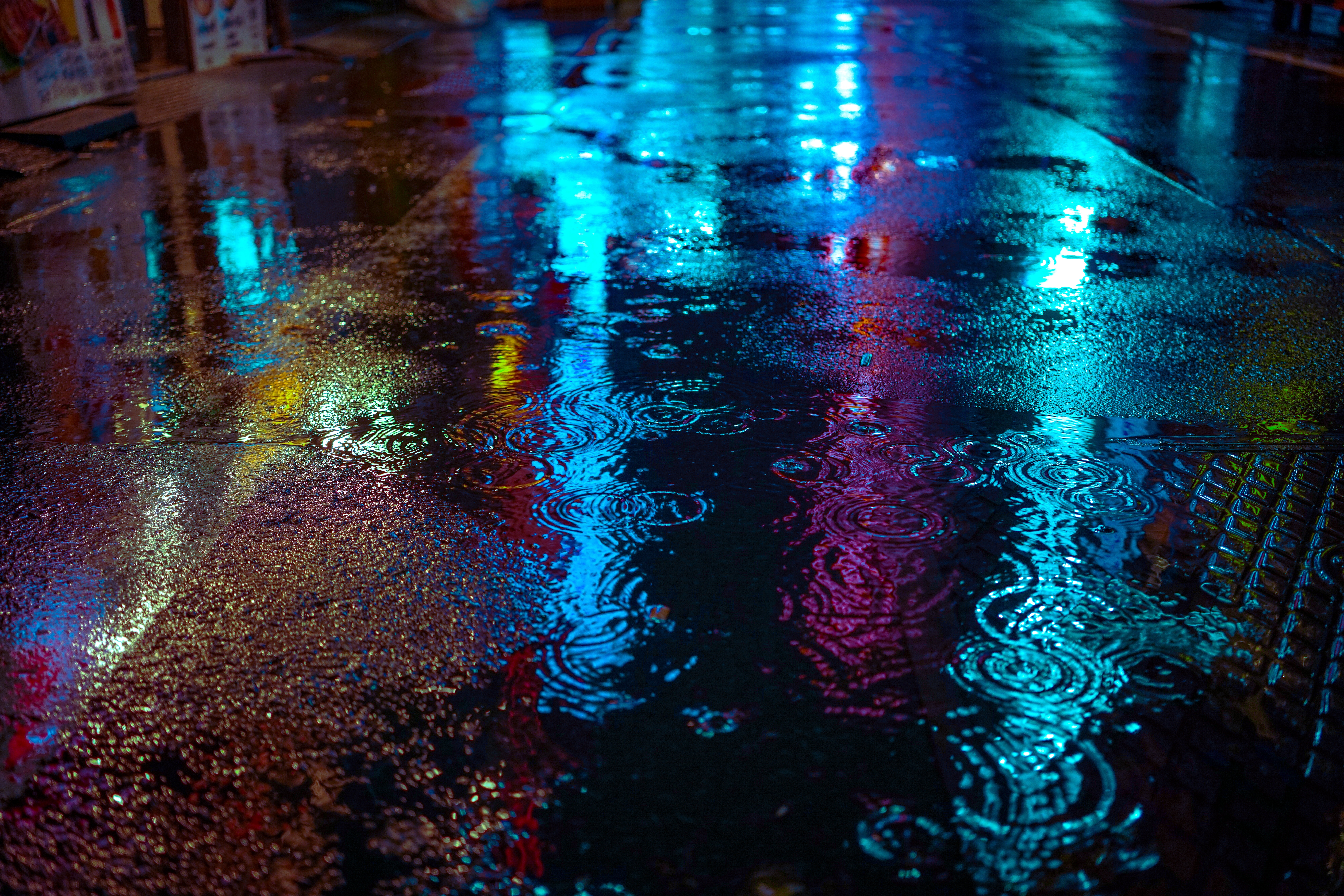 Neon reflections on a wet city street at night HD Wallpaper