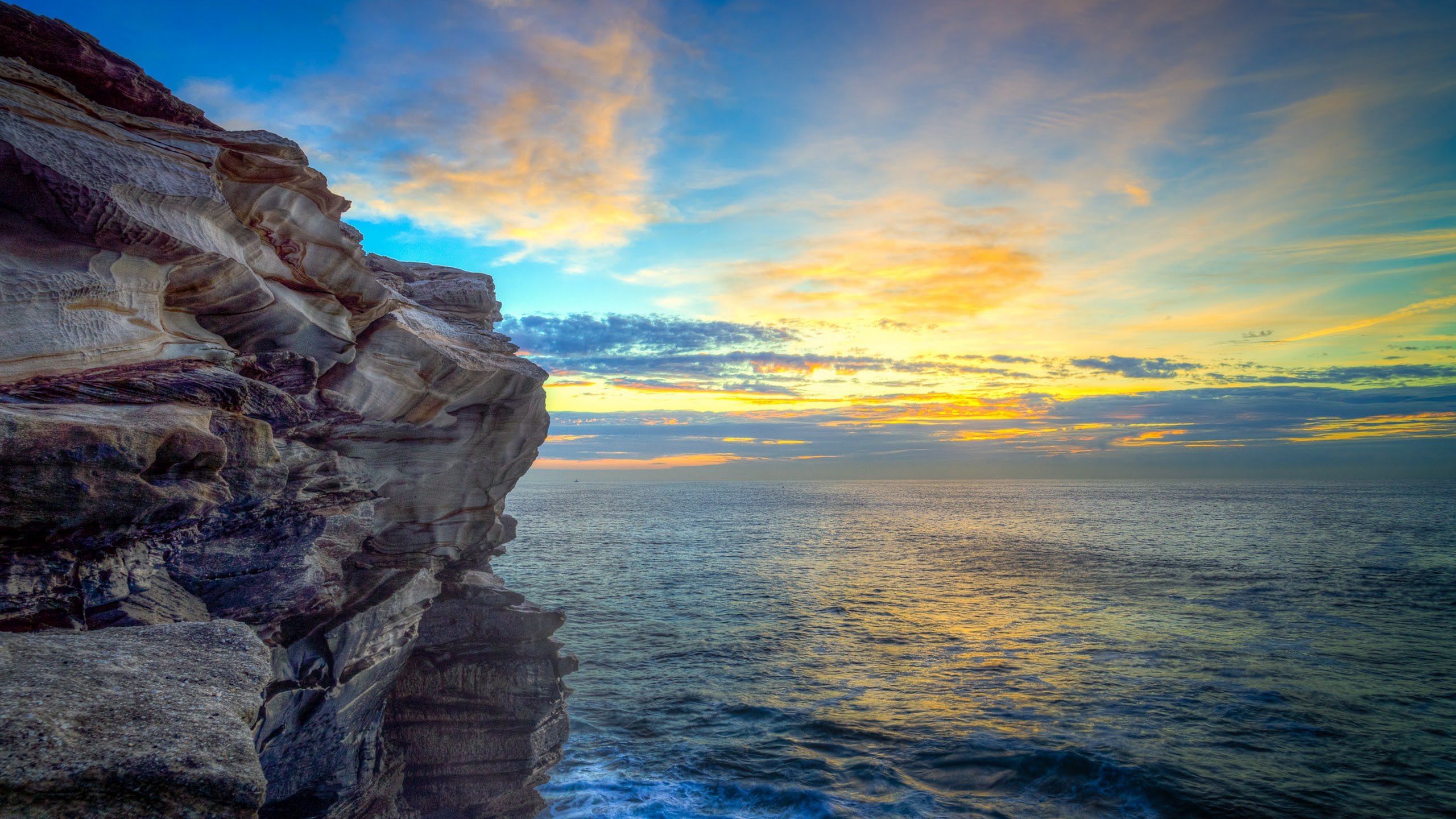 Ocean cliff at sunset with colorful clouds HD Wallpaper