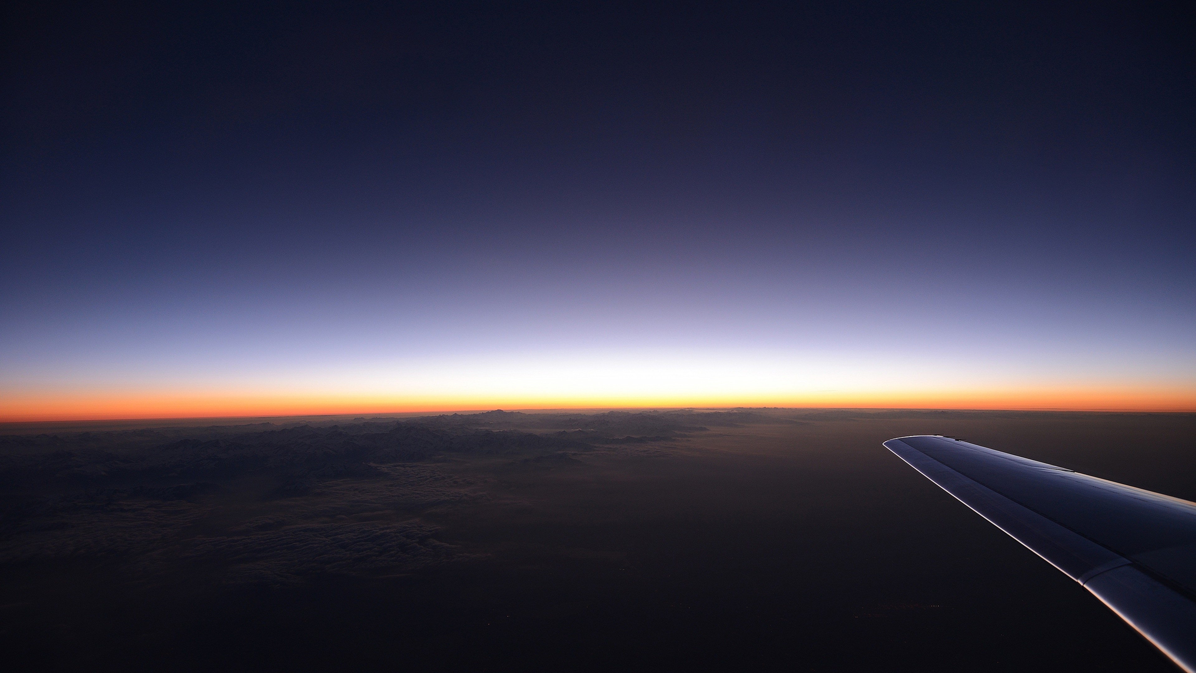 Airplane wing over mountains at sunset 4K HD Wallpaper
