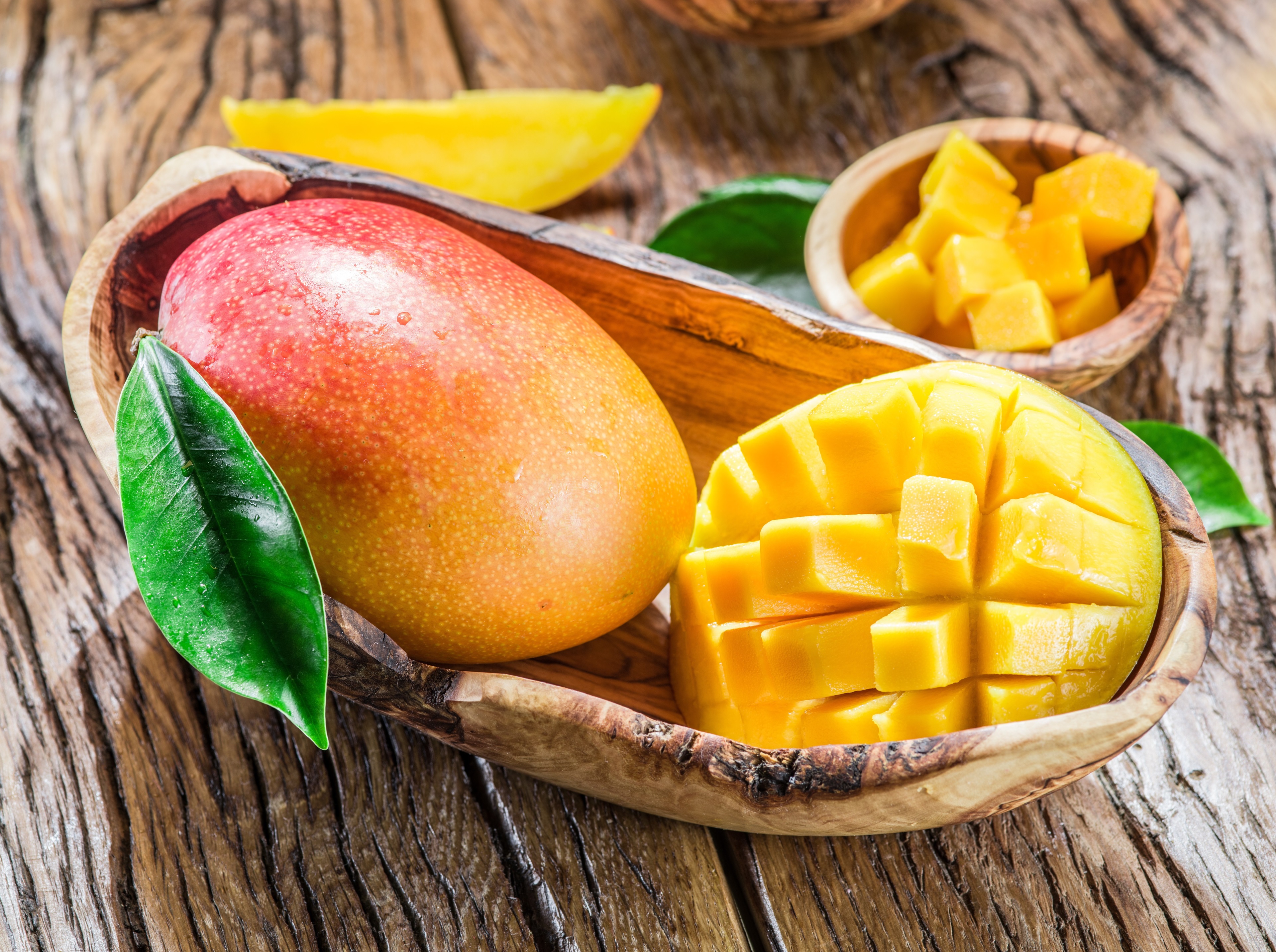 Mangoes in wooden bowls on a rustic table HD Wallpaper
