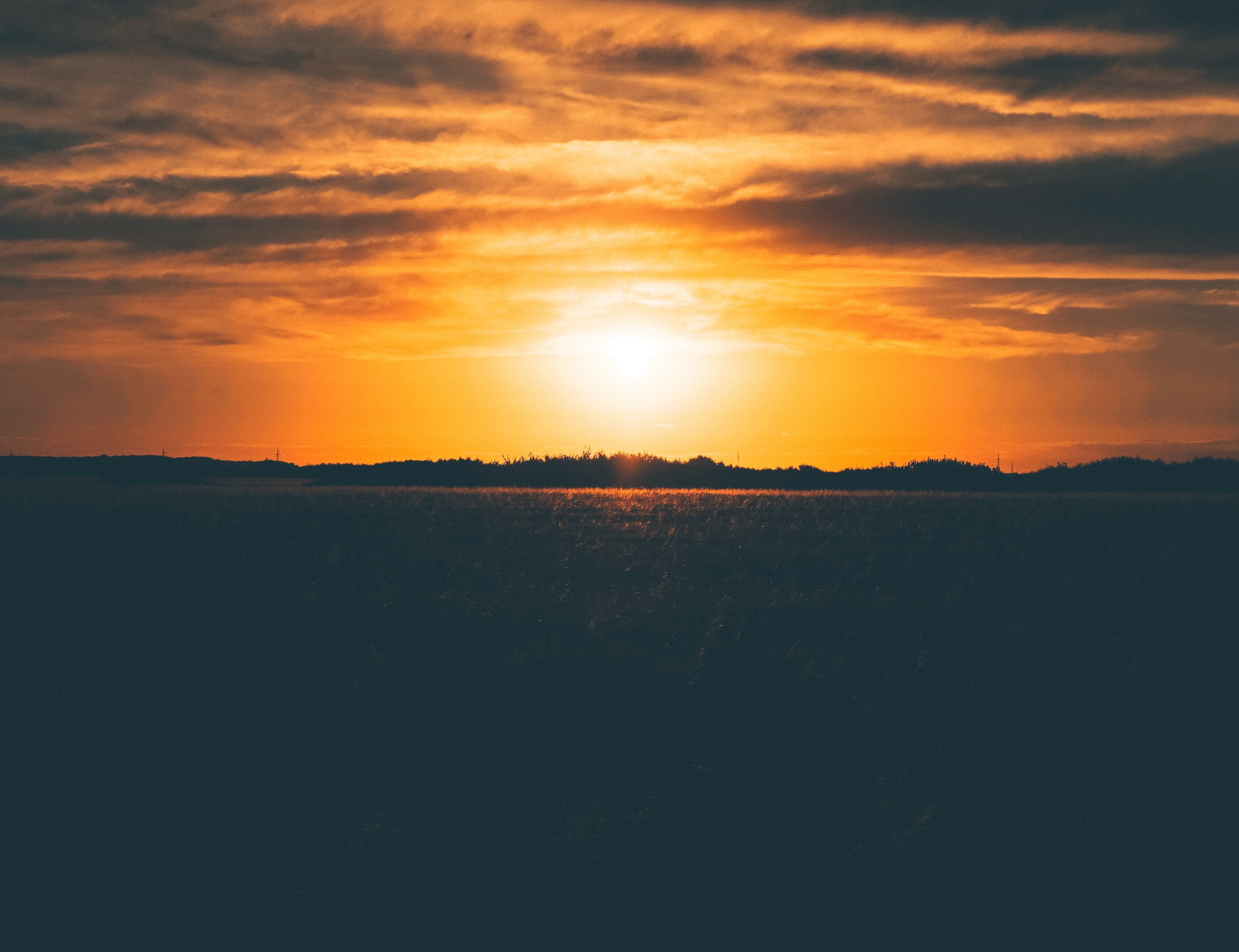 Sunset over a dark field HD Wallpaper