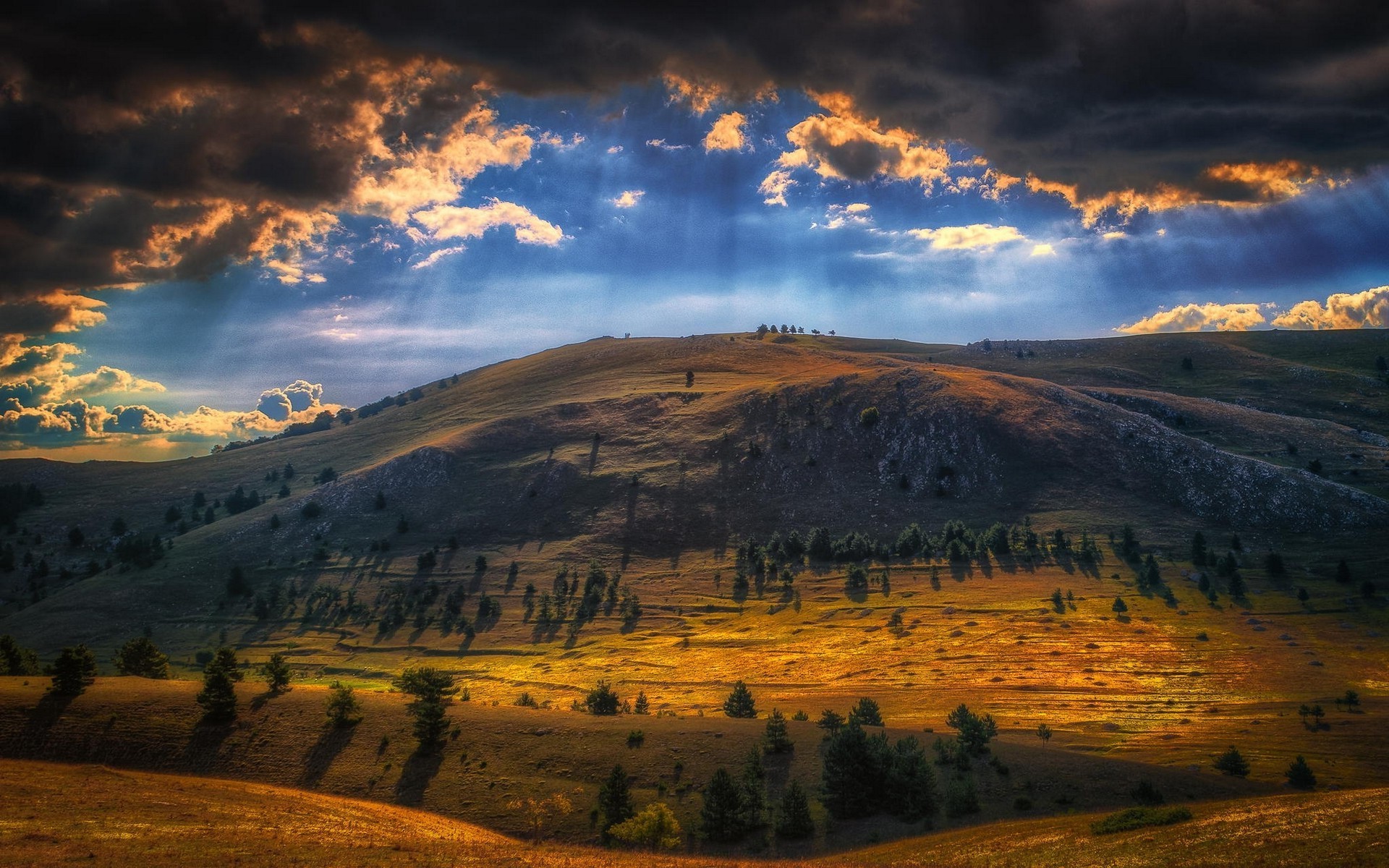 Sun rays over a mountain landscape with clouds and trees HD Wallpaper
