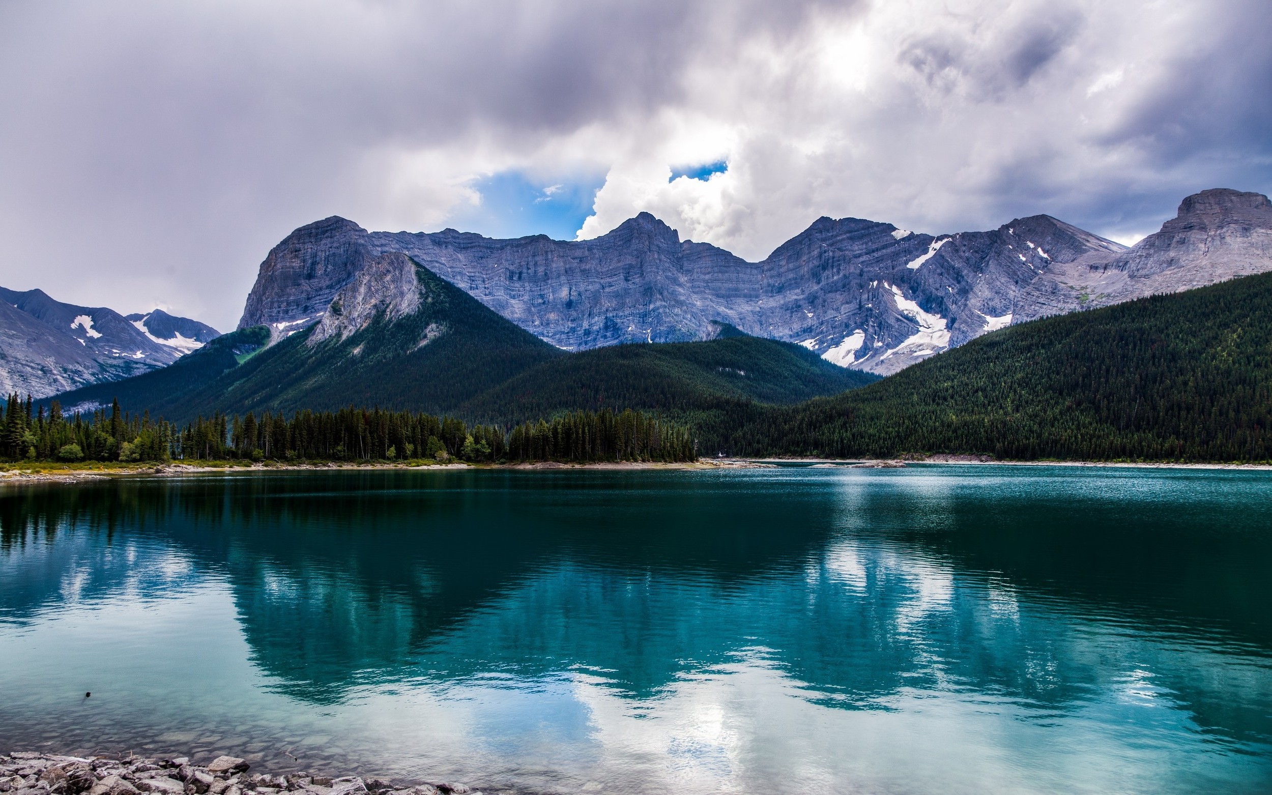 Lake reflection of mountains and forest under cloudy sky in Alberta, Canada HD Wallpaper