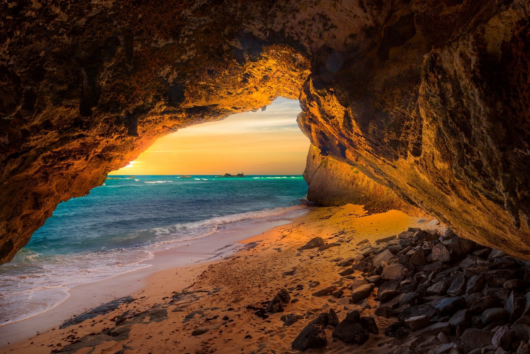 Cave opening to a beach and ocean at sunset HD Wallpaper
