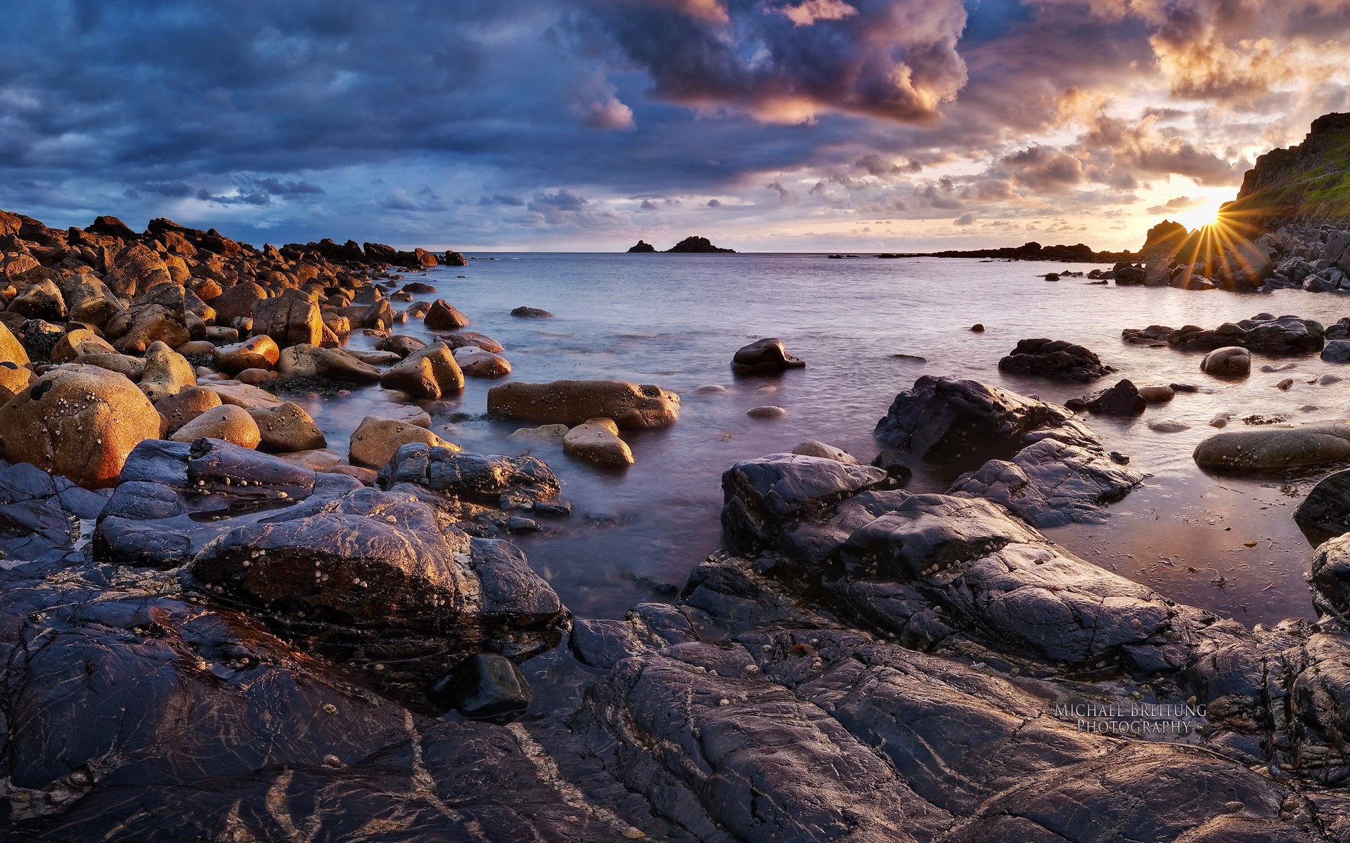 Rocky coastline at sunset with dramatic clouds HD Wallpaper