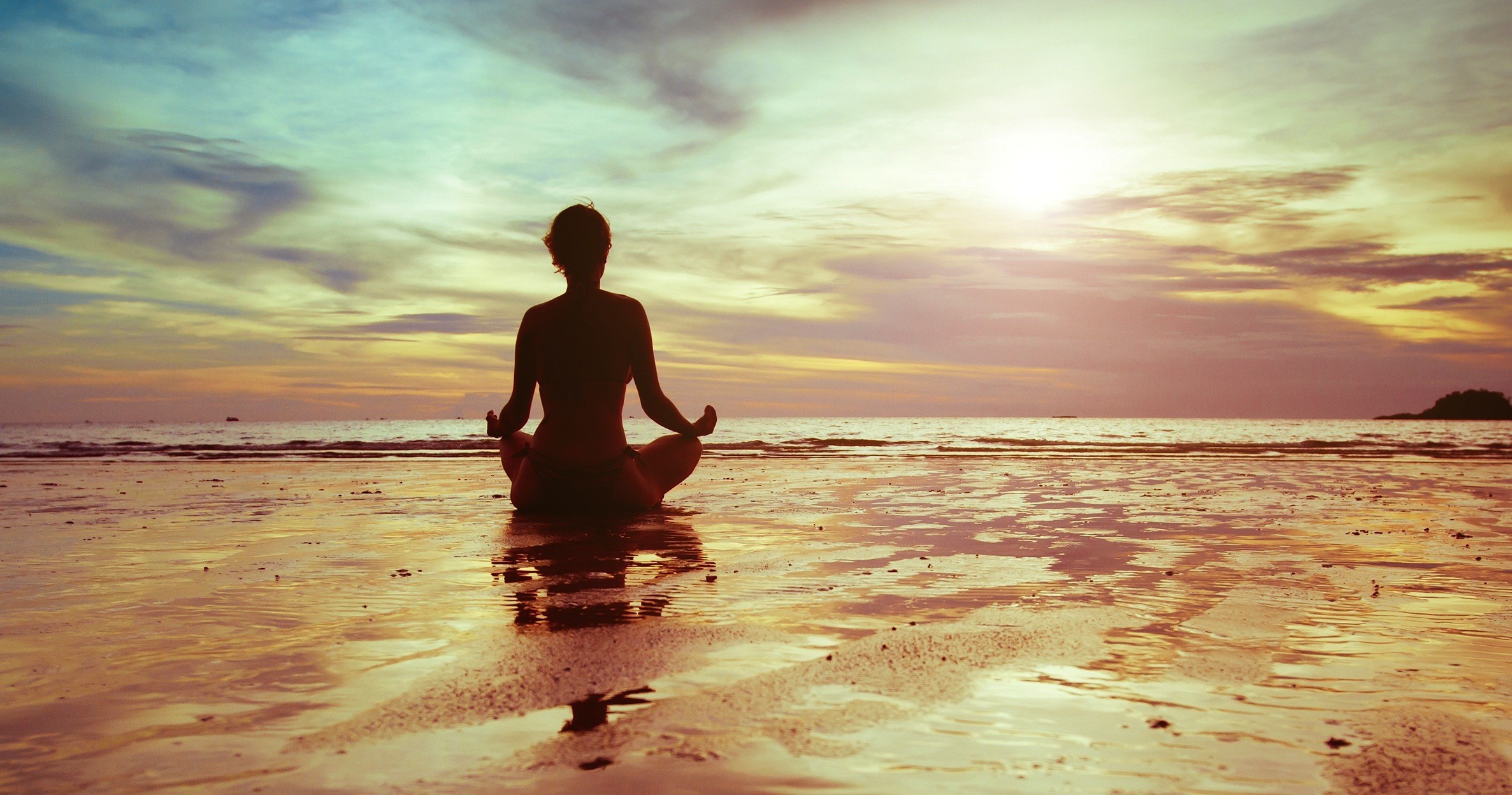 Woman meditating on a beach at sunset HD Wallpaper