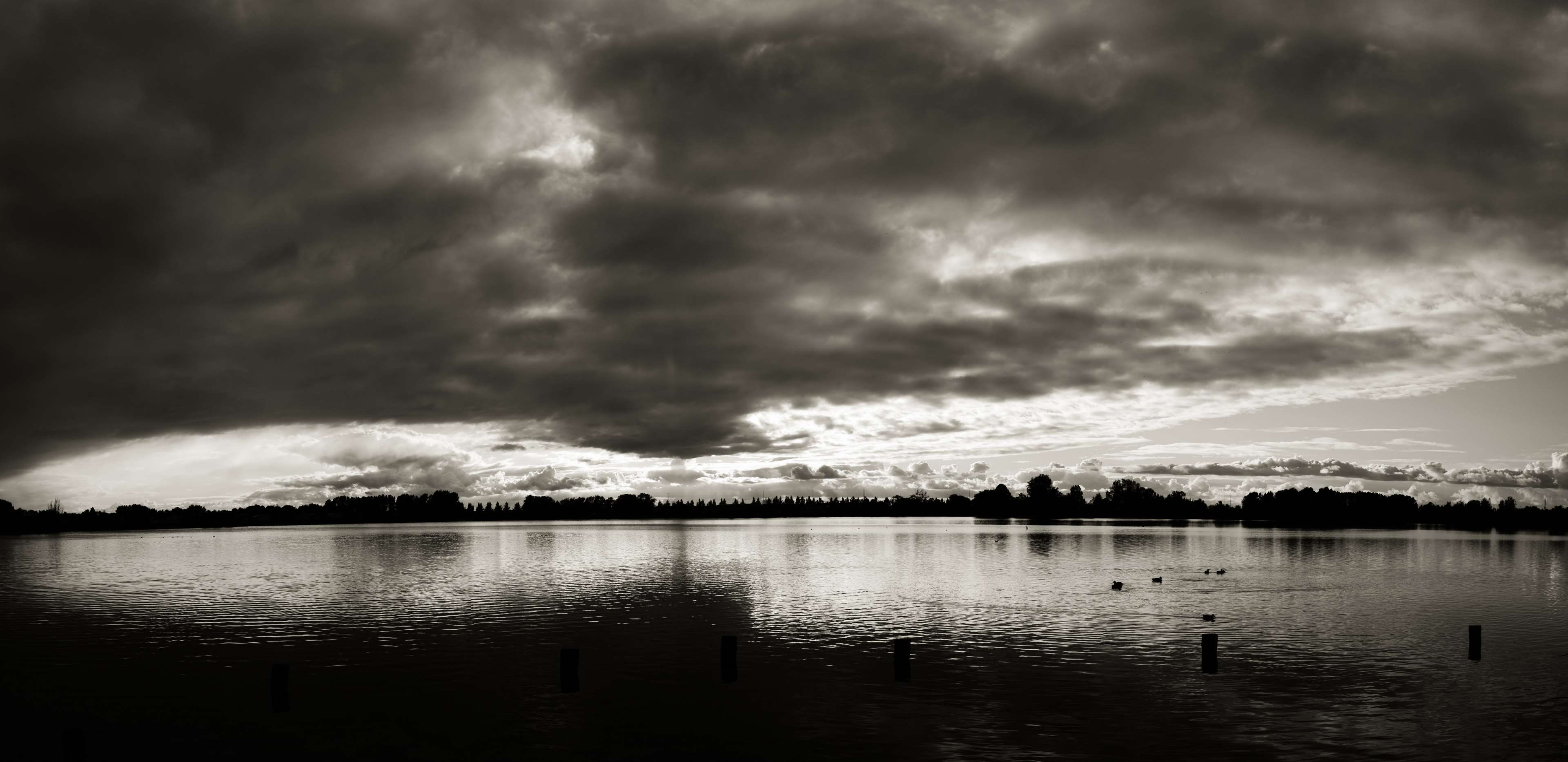 Dark storm clouds over a lake at dusk HD Wallpaper