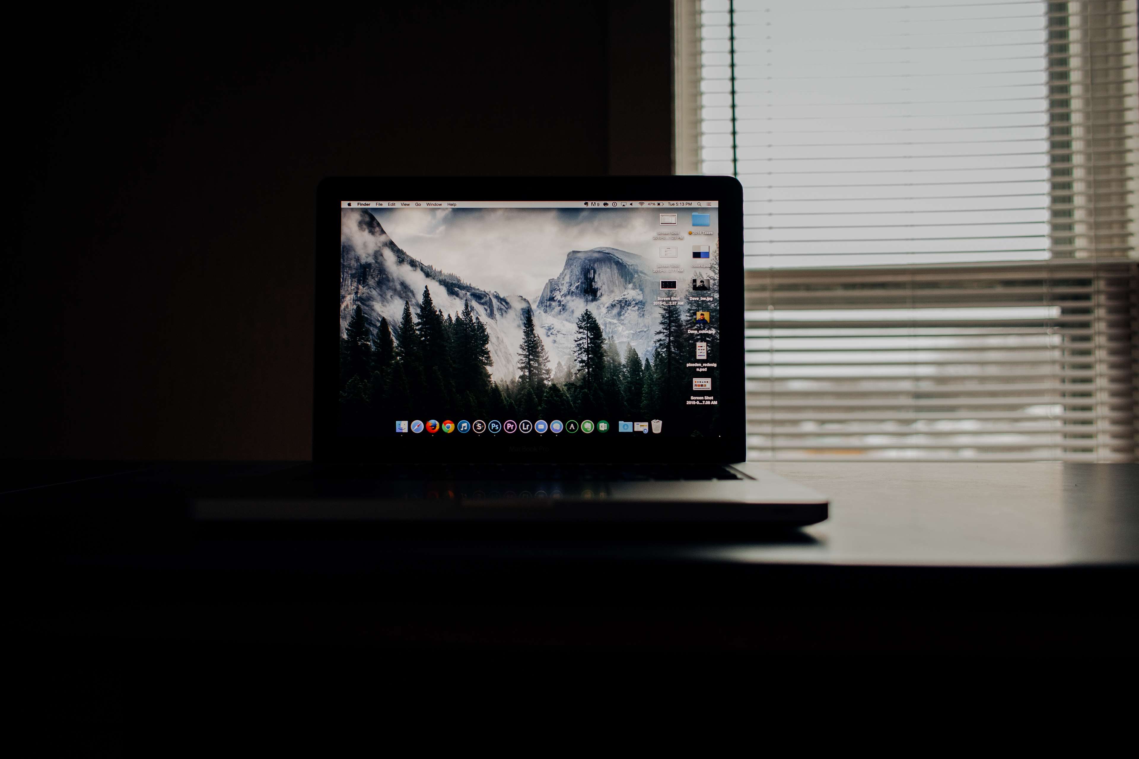 MacBook with mountain wallpaper on a desk HD Wallpaper