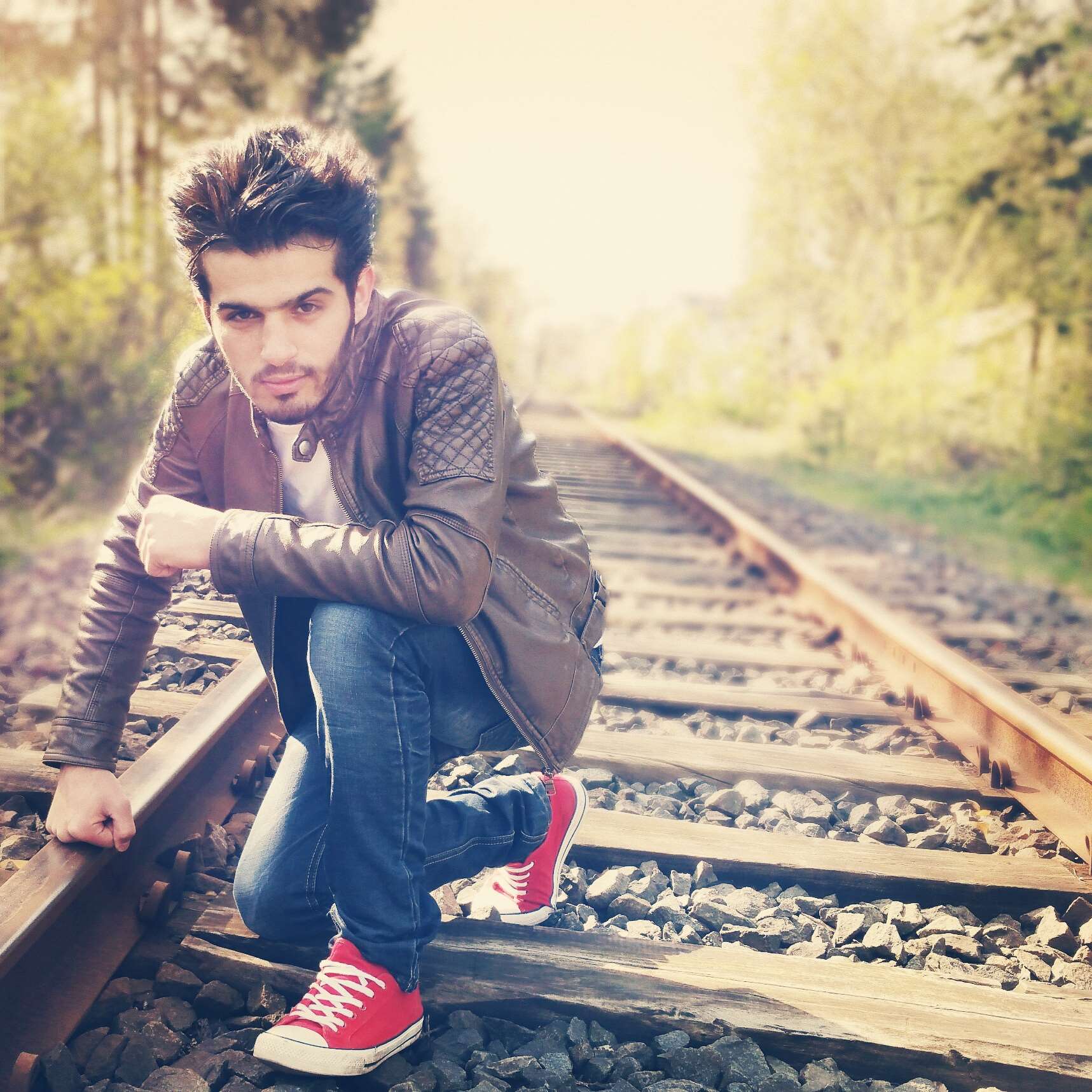 Man crouching on railroad tracks HD Wallpaper